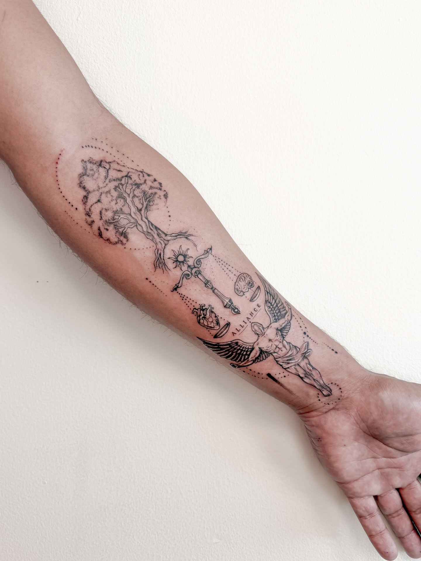 Tree and angel dotwork tattoo on the forearm by Tatuajes Denver