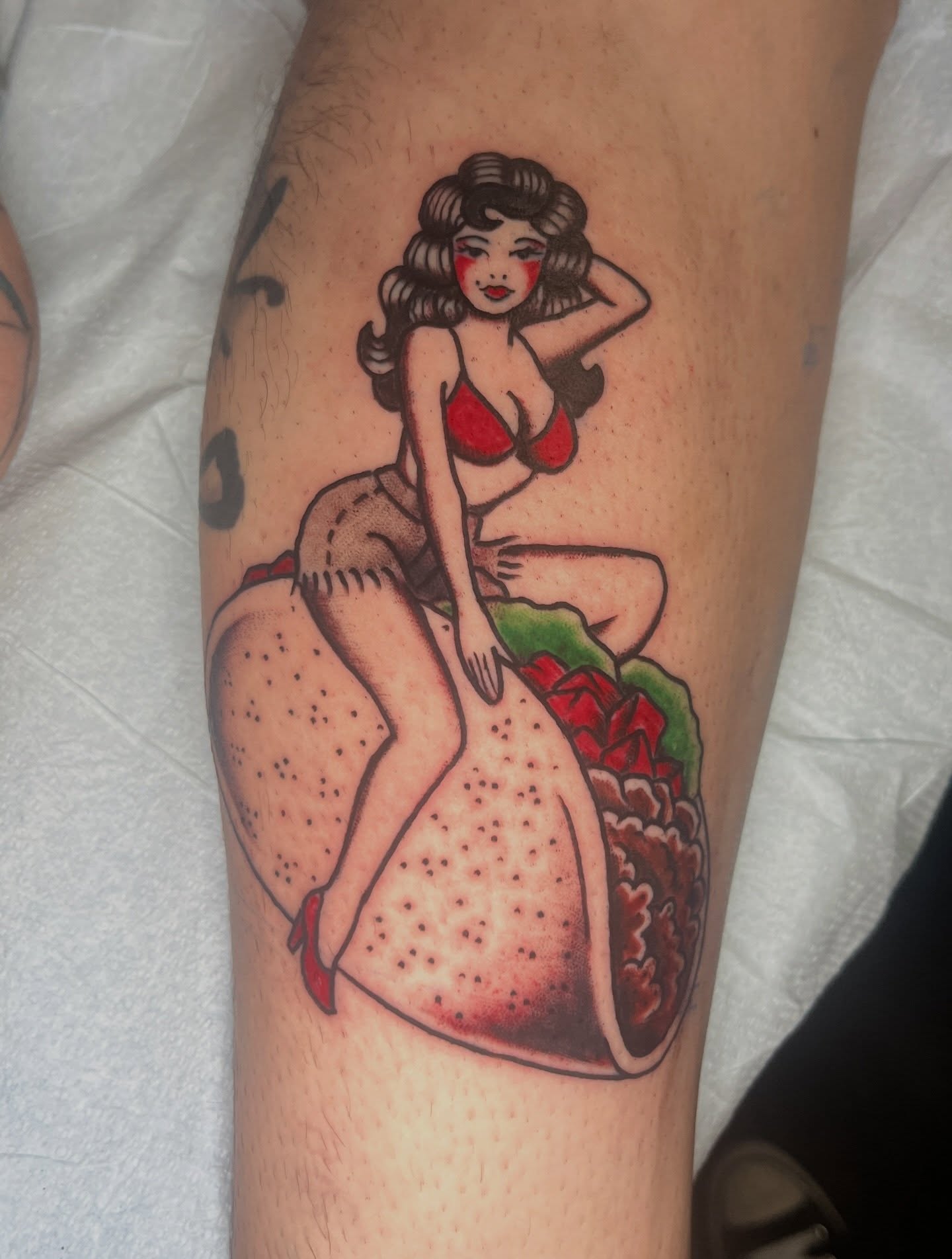 Pin-up girl taco American traditional tattoo on the forearm by Ryan Kim