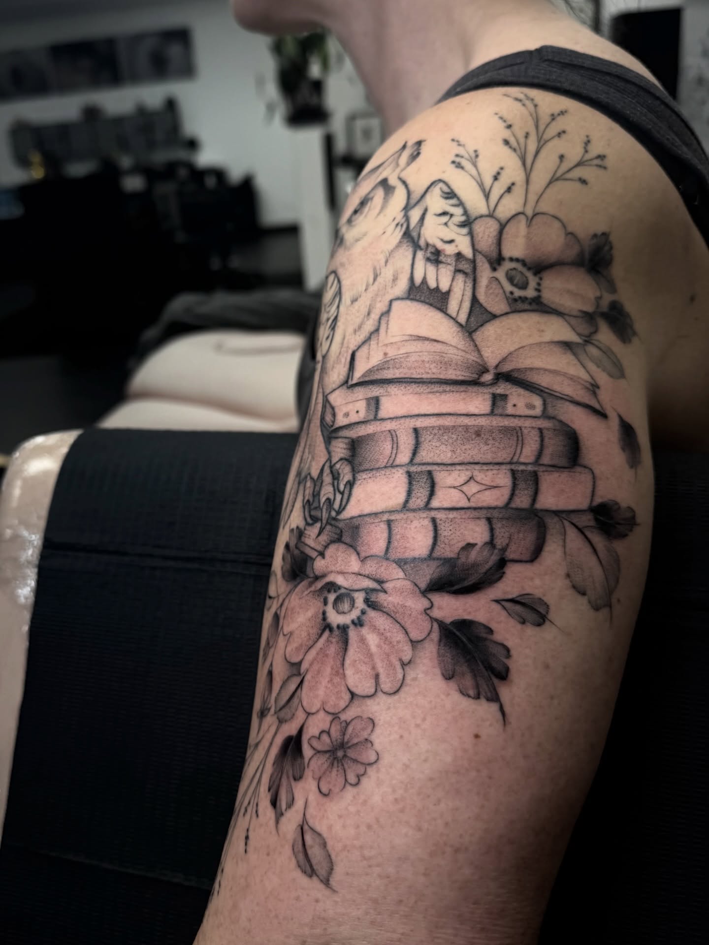 Bookshelf with flowers black and grey tattoo on the upper arm by Chloe