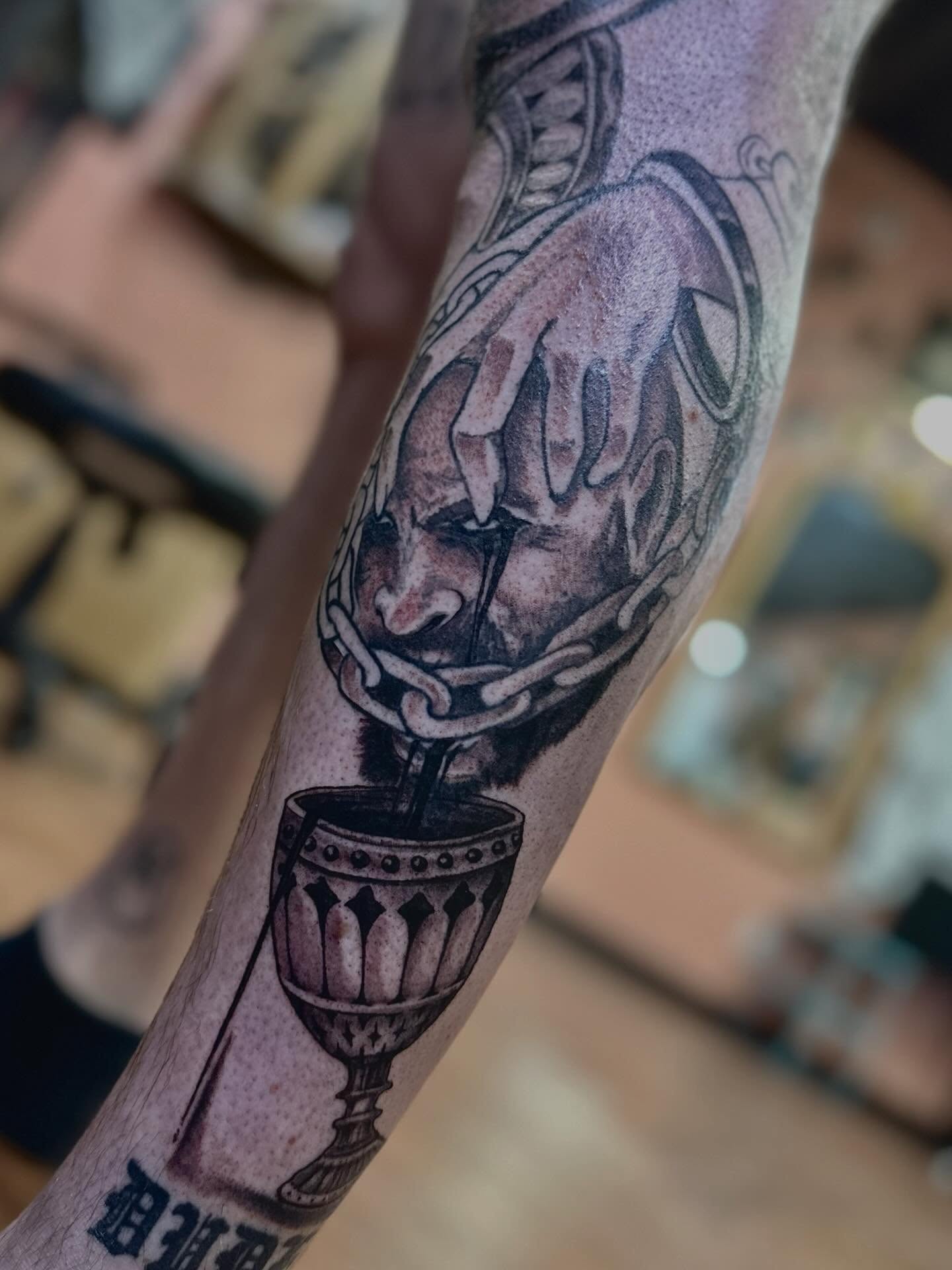 Man's head with chains realism tattoo on the forearm by Mathilda Quynh