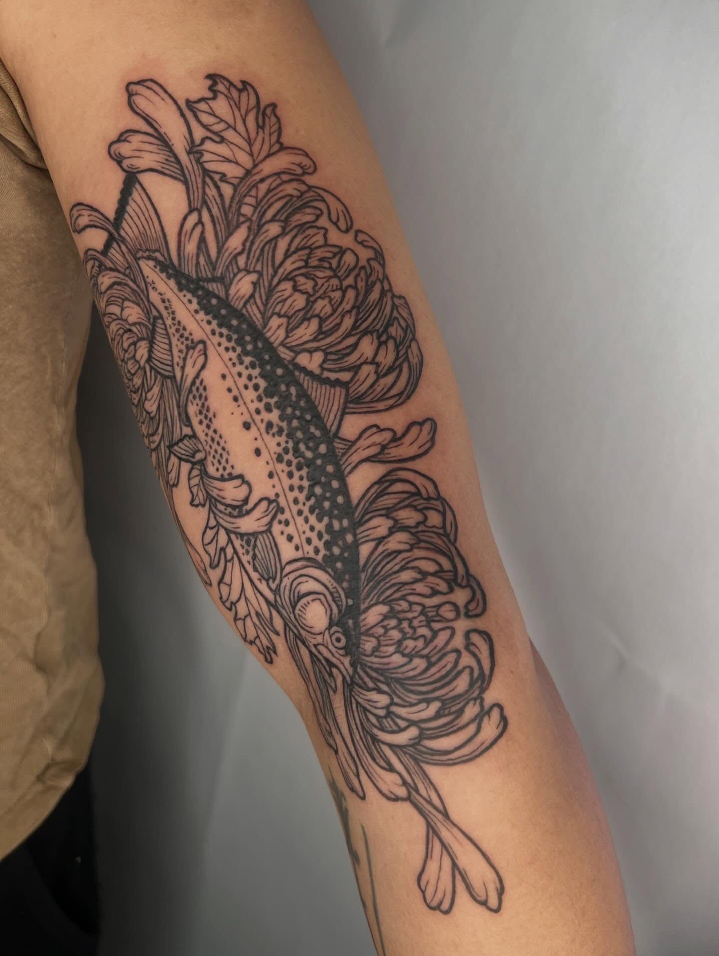 Fish and flowers dotwork tattoo on the forearm by Jason Middelton