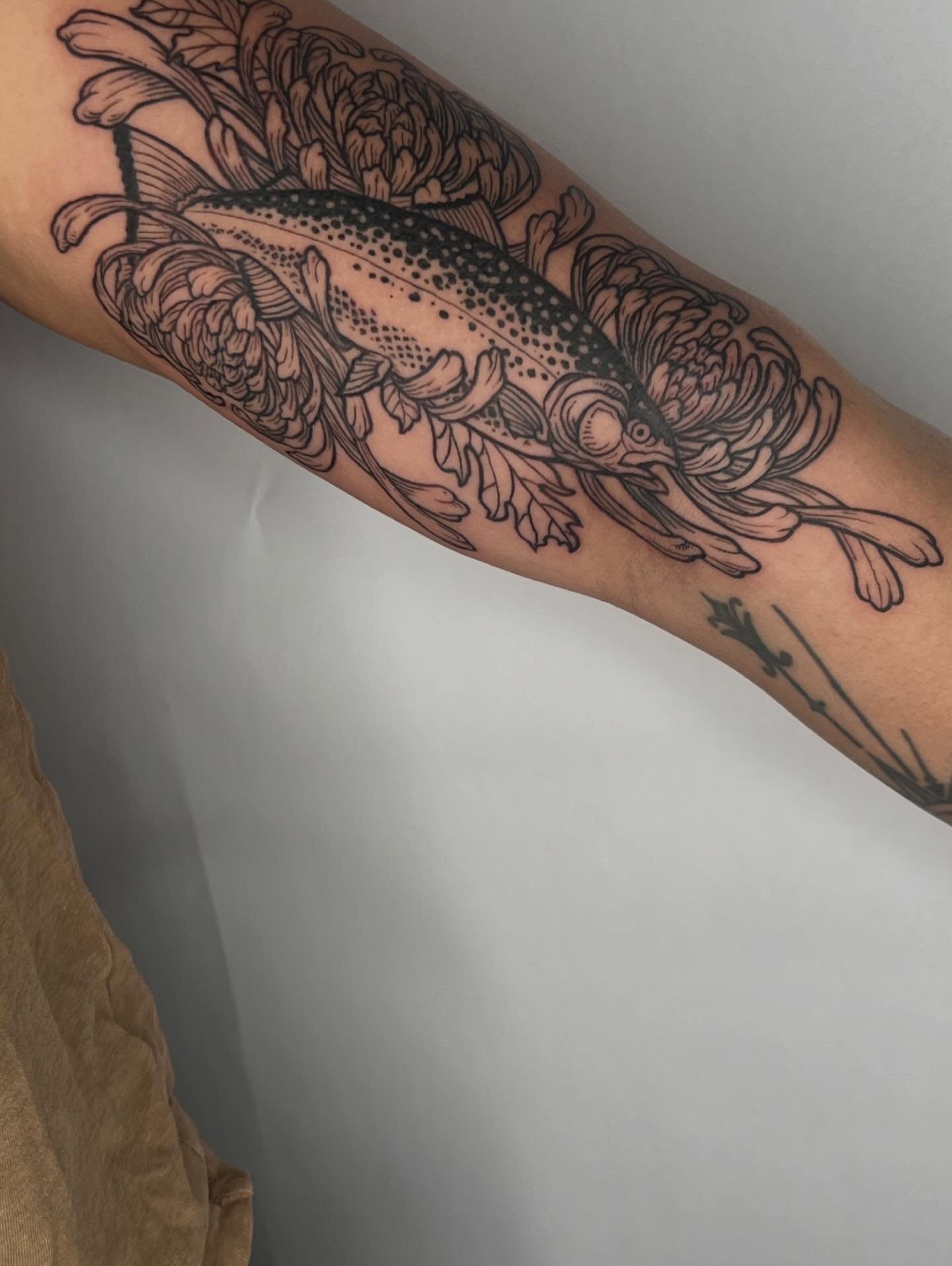 Fish and flowers dotwork tattoo on the forearm by Jason Middelton