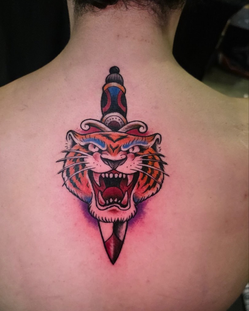 Tiger head with dagger American traditional tattoo on the back by Tank Maass