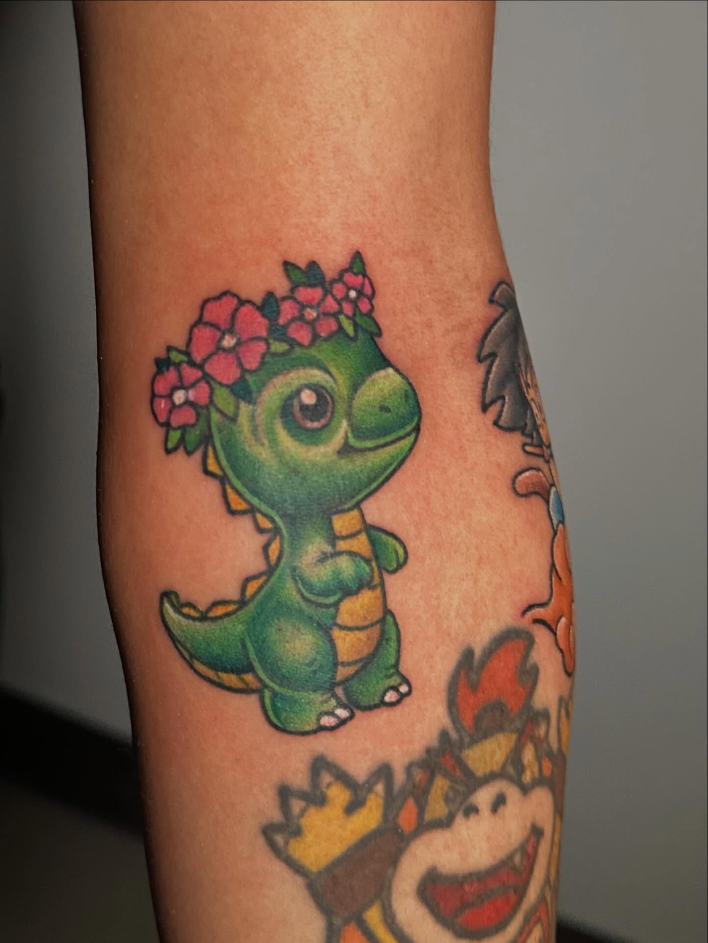 Dinosaur with flower crown new school tattoo on the forearm by Chi, Charlotte, North Carolina