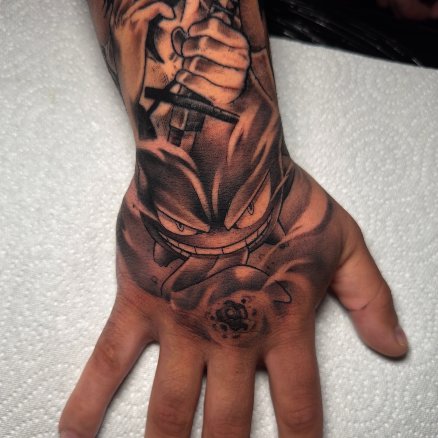 Gengar dark realism tattoo on the hand by Cristian Romero