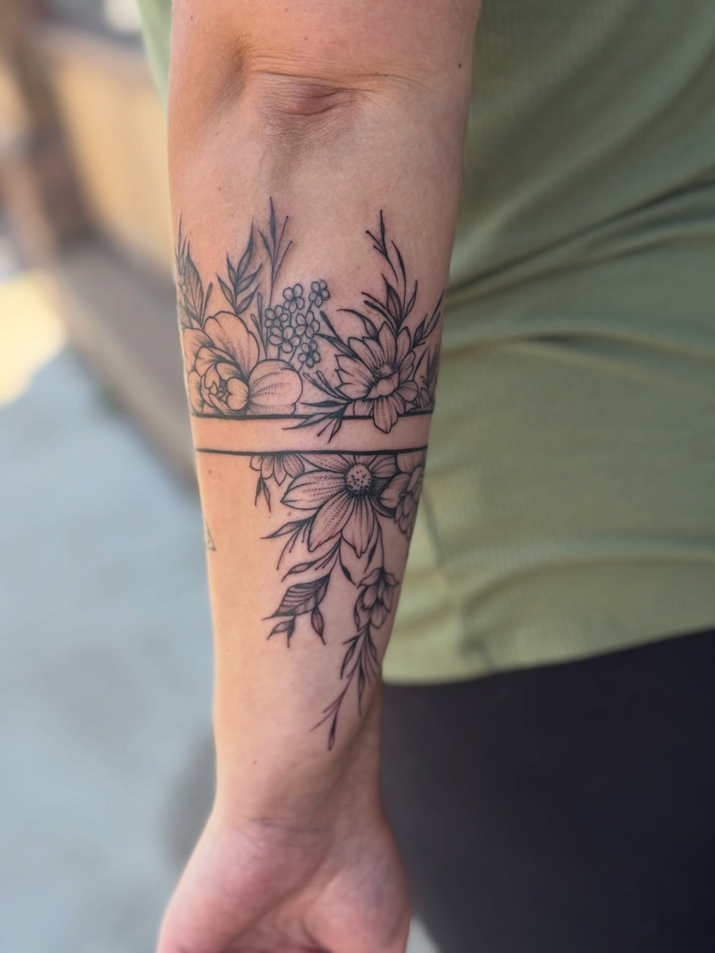 Floral arrangement black and grey tattoo on the forearm by Emily Velletta, Huntersville, North Carolina