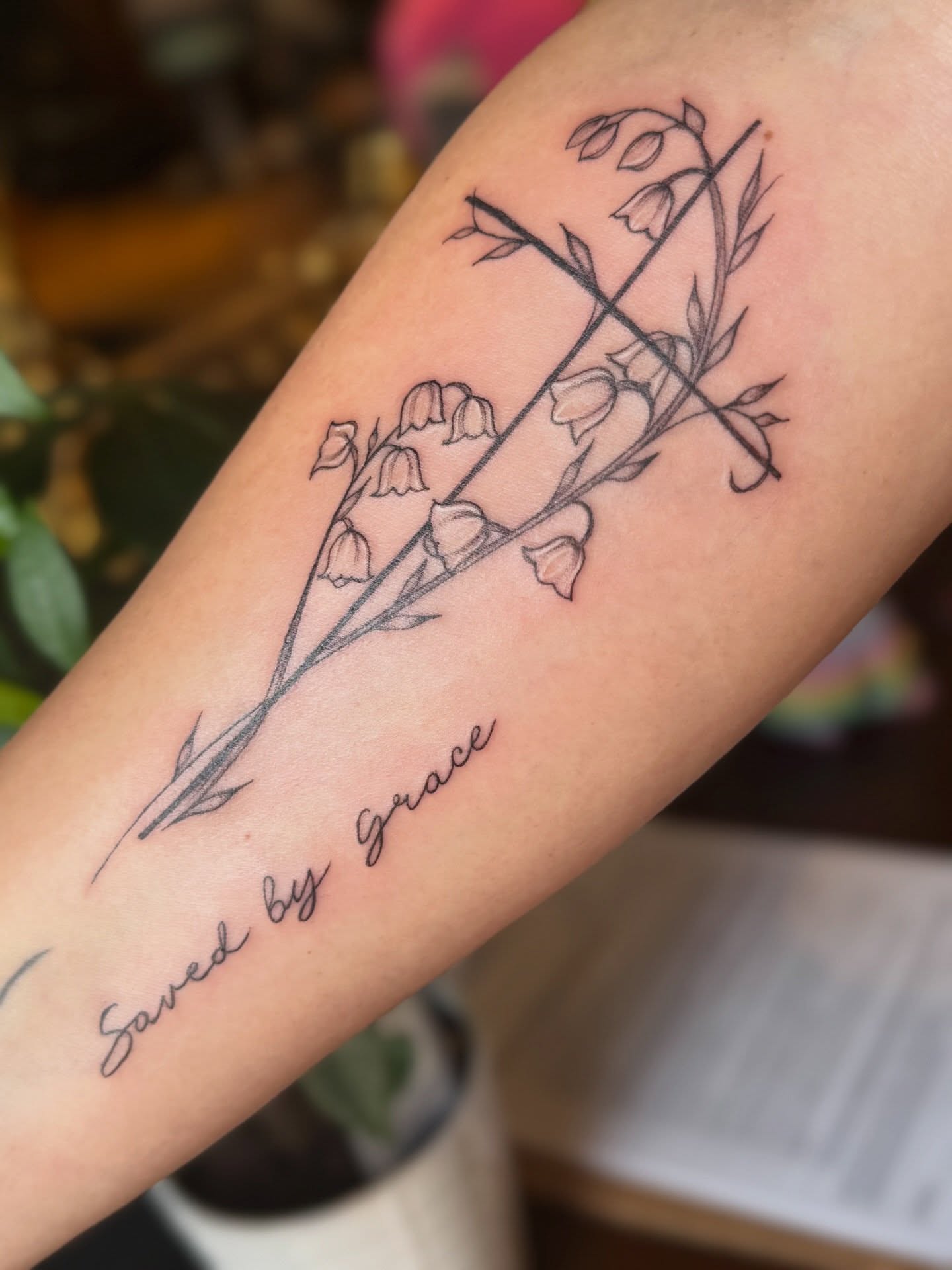 Bell flowers and cross fine line tattoo on the forearm by Emily Velletta, Huntersville, North Carolina