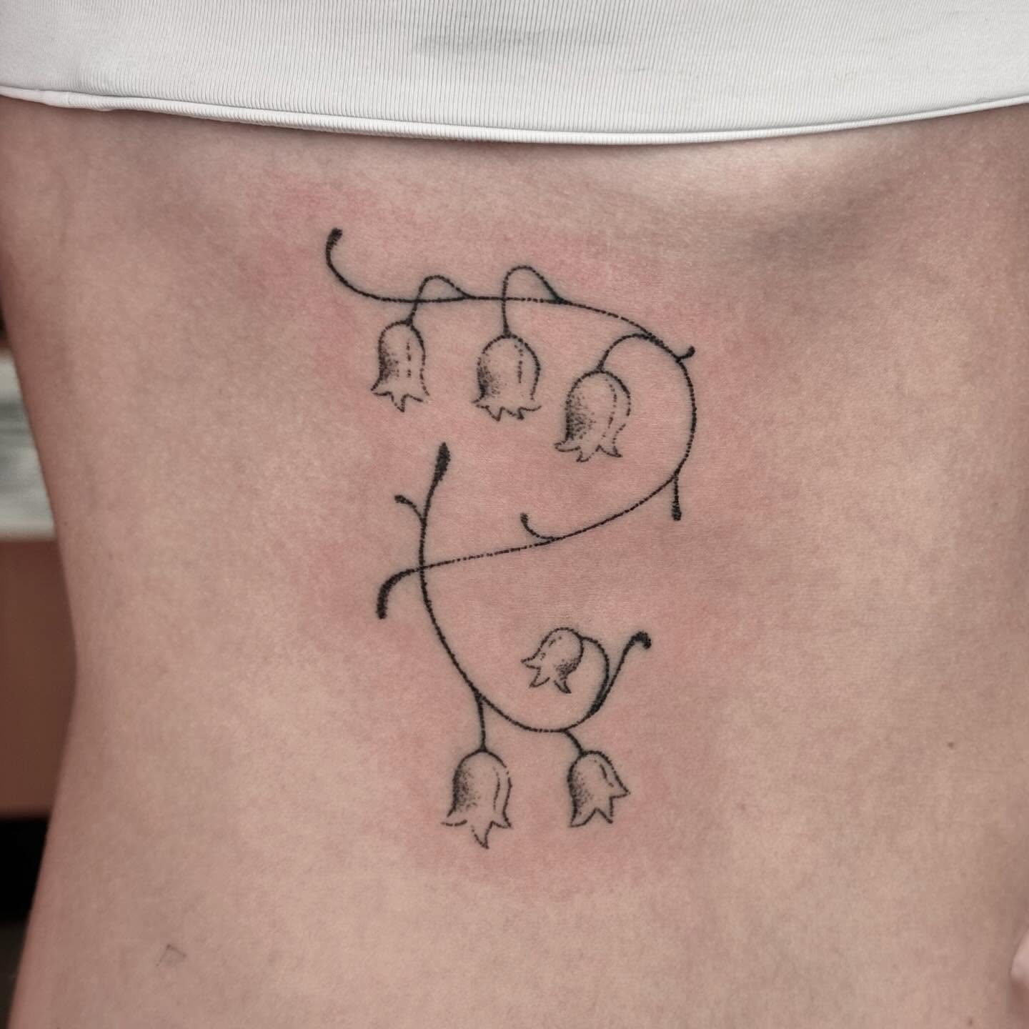 Bell flowers minimalist tattoo on the ribs by πΏππΌππ πππππππ