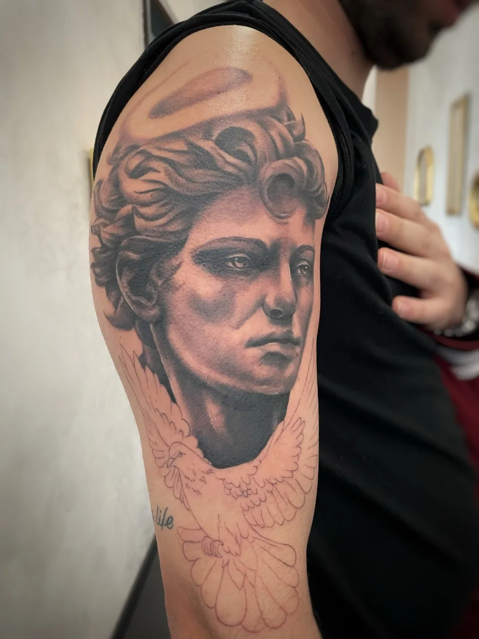 Statue portrait realism tattoo on the upper arm by Blot_Tattoo
