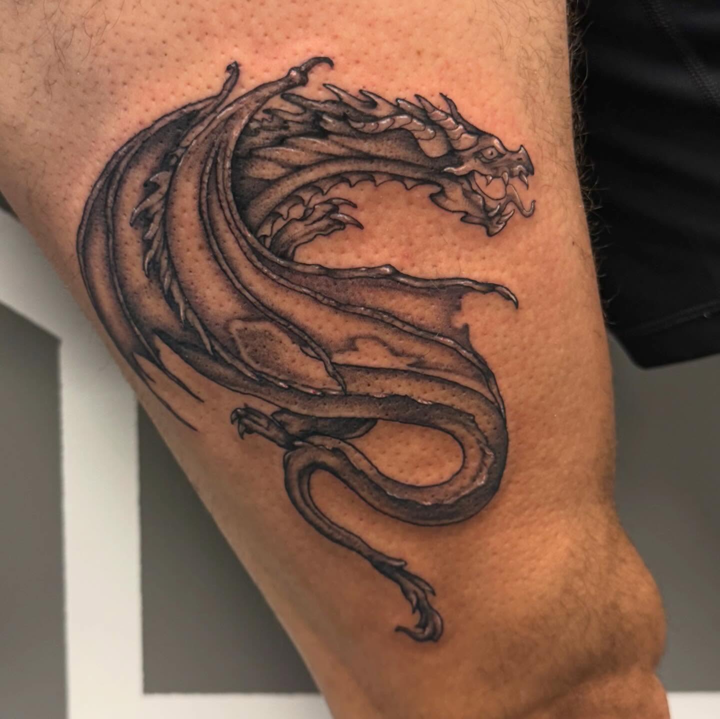Dragon black and grey tattoo on the forearm by Katie Rojas