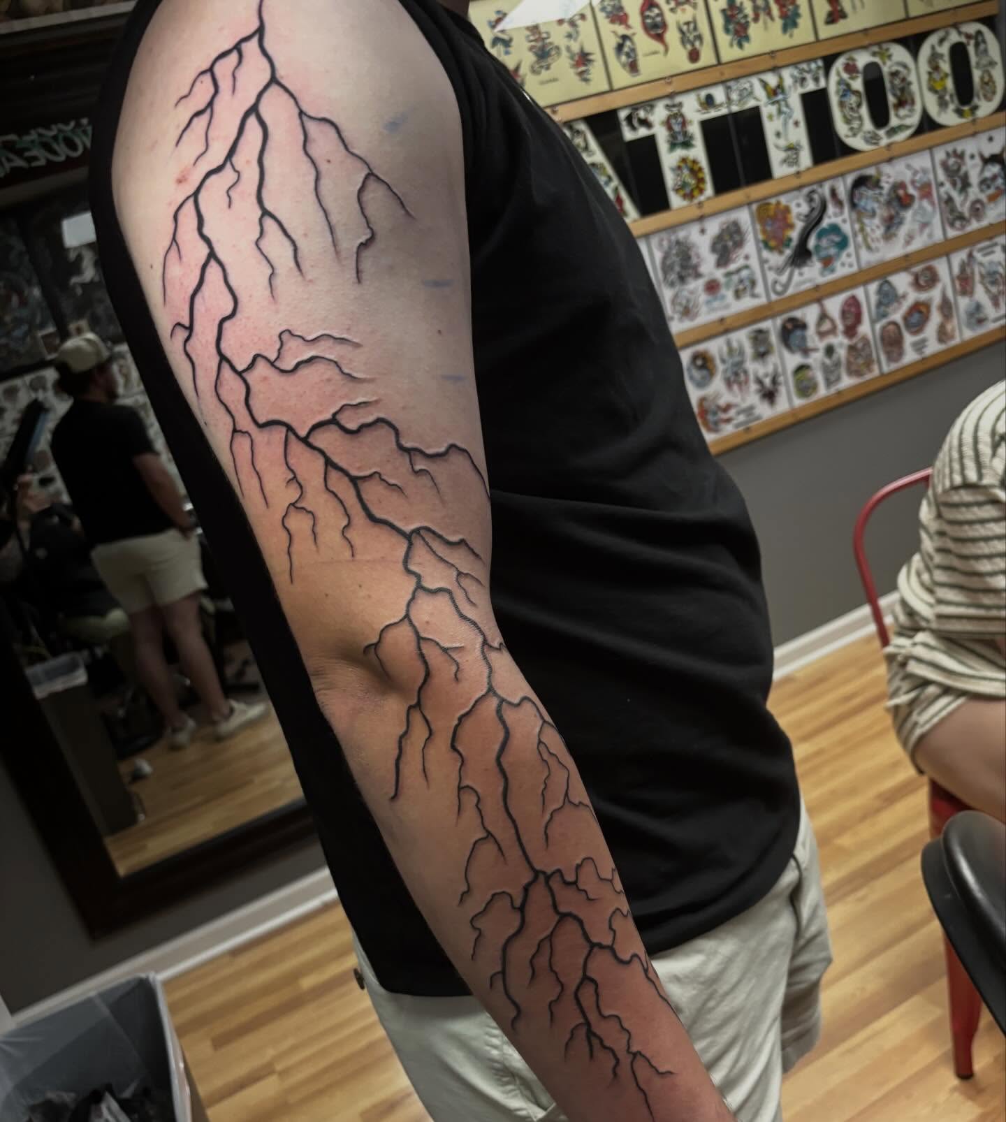 Lightning bolts black and grey tattoo on the forearm by Chris Dufresne