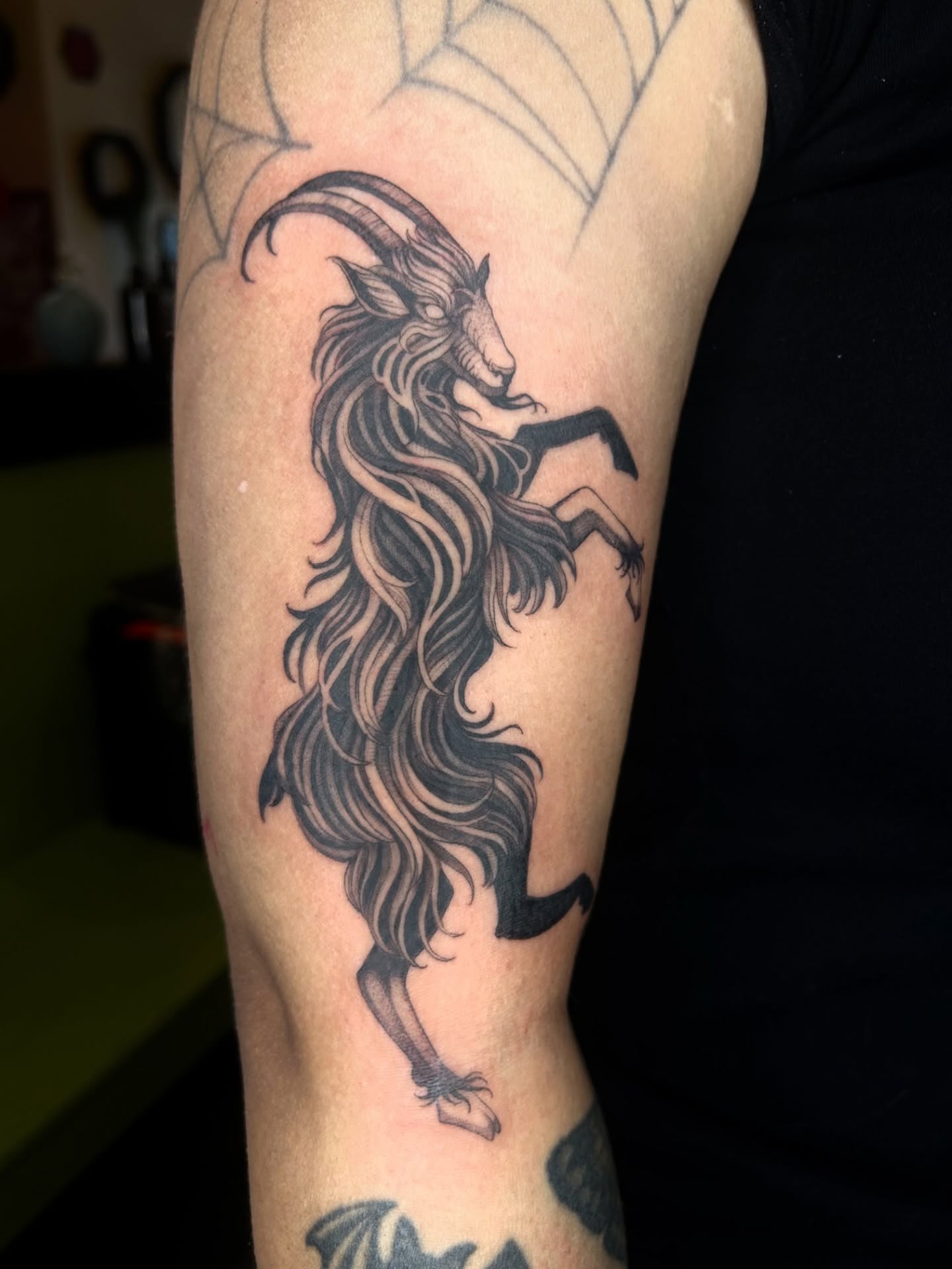 Goat with long hair black and grey tattoo on the forearm by Magnus