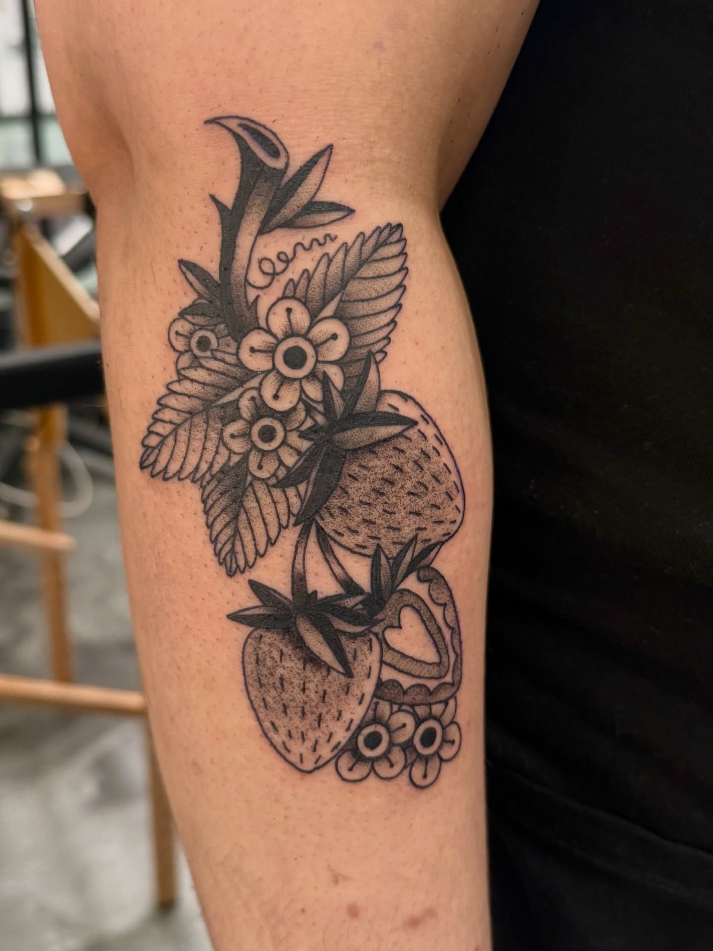 Strawberries and flowers black and grey tattoo on the forearm by Sophie McTear
