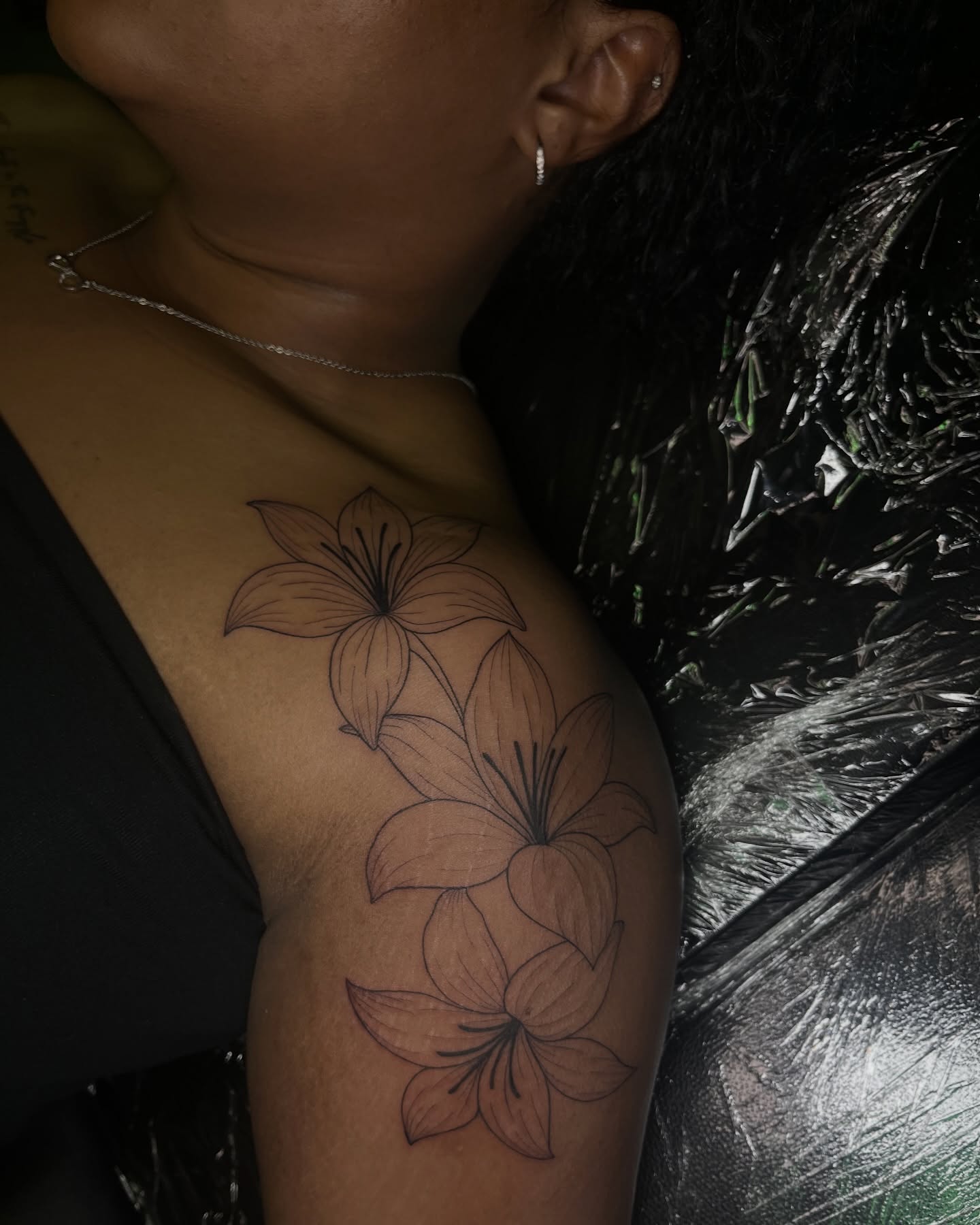 Lilies black and grey tattoo on the shoulder by Daniela
