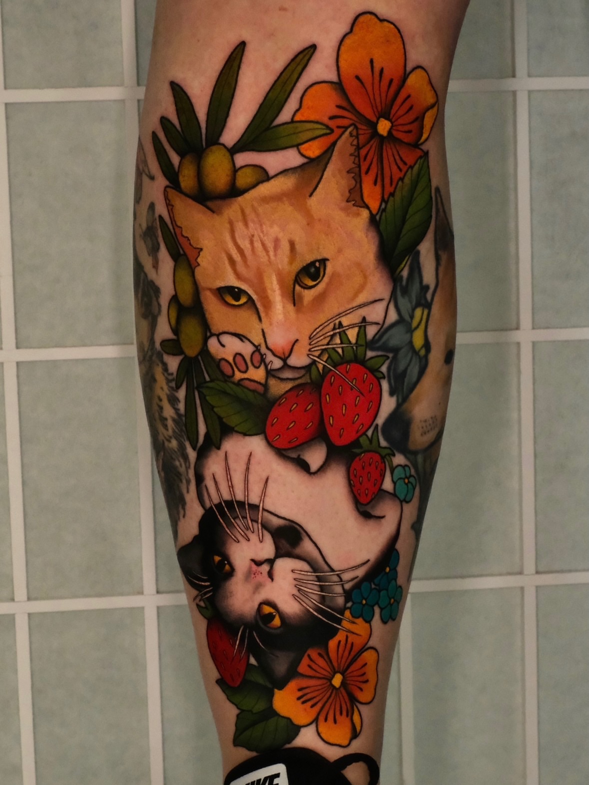 Cats and strawberries American traditional tattoo on the forearm by Mallory Murphy, Denton, Texas