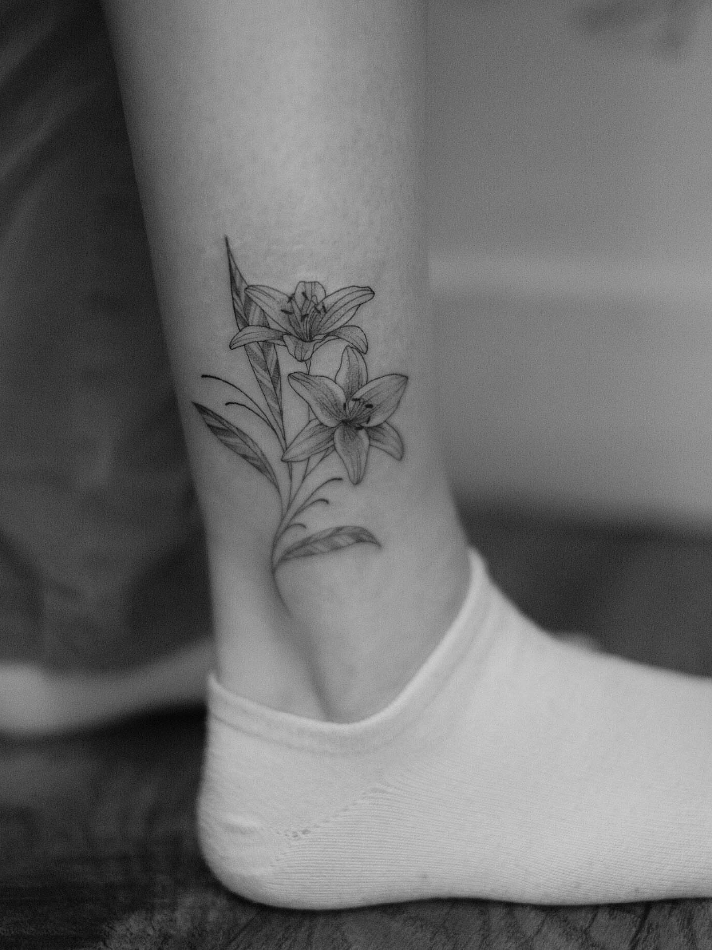 Lilies black and grey tattoo on the foot by Isabelle Kellar, San Diego, California