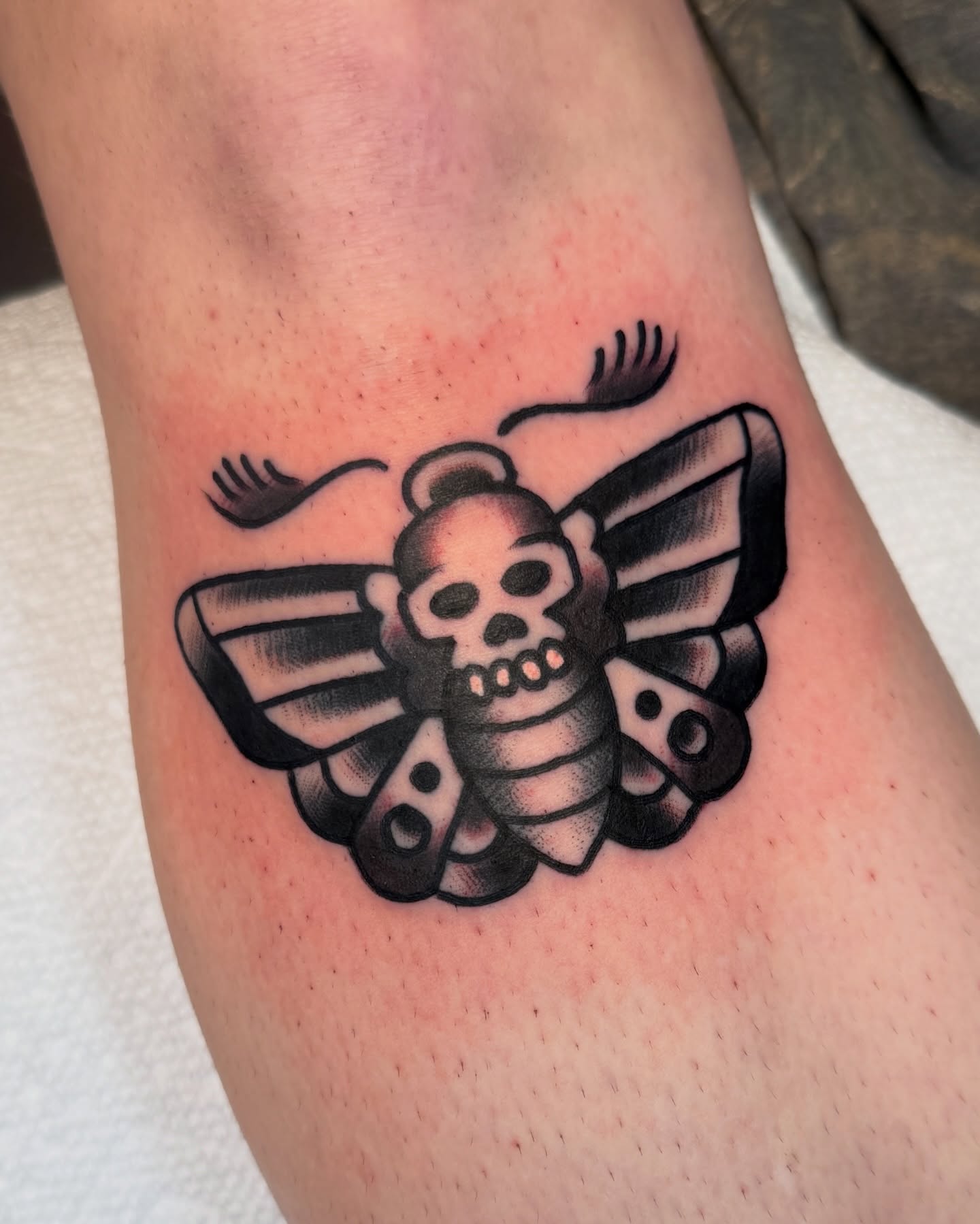 Skull and butterfly black and grey tattoo on the forearm by Cullen Bleser Quinn
