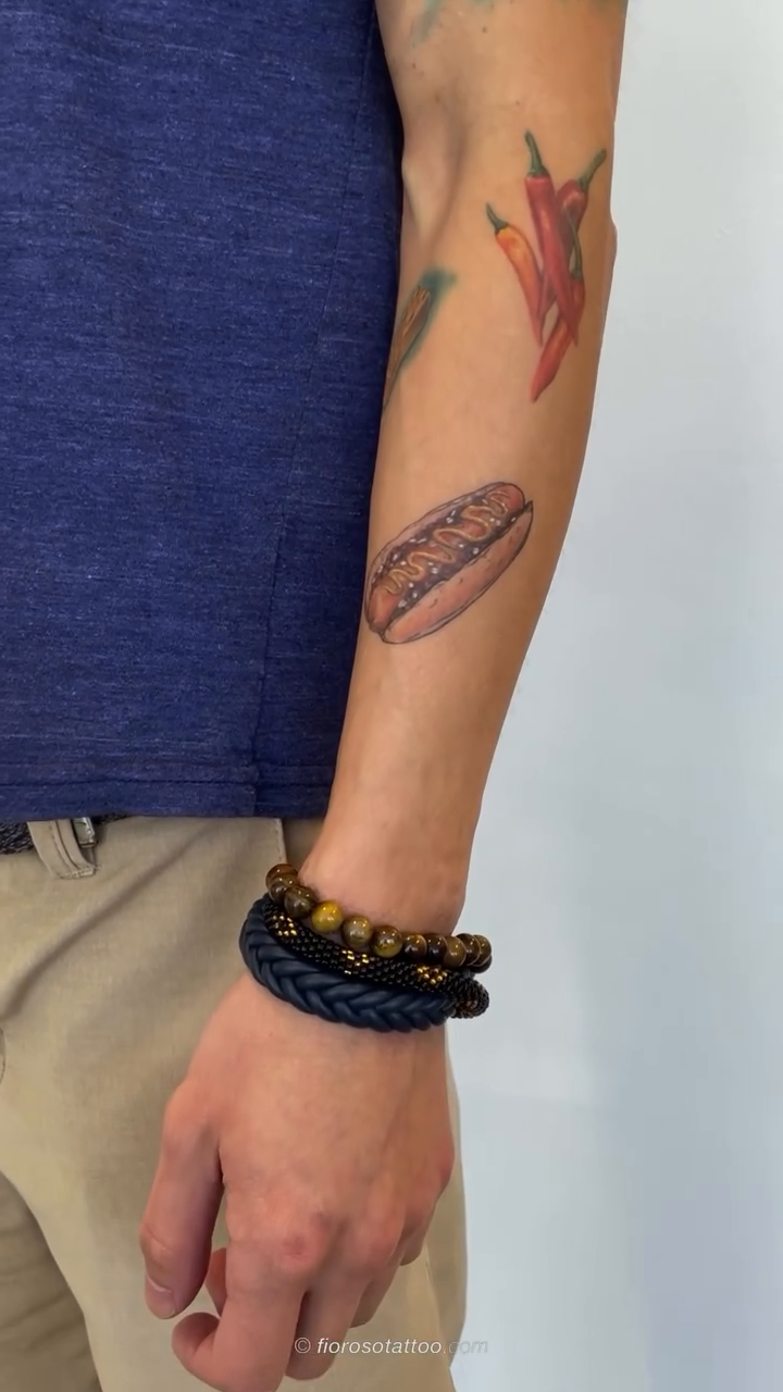 Hot dog and chili peppers minimalist tattoo on the forearm by Jonathan Paul Fiore, Austin, Texas