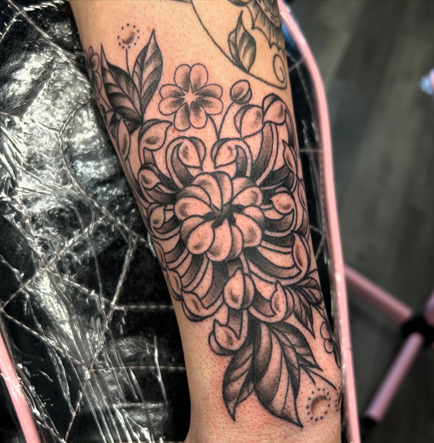 Floral bouquet black and grey tattoo on the forearm by Audrey Migitsch