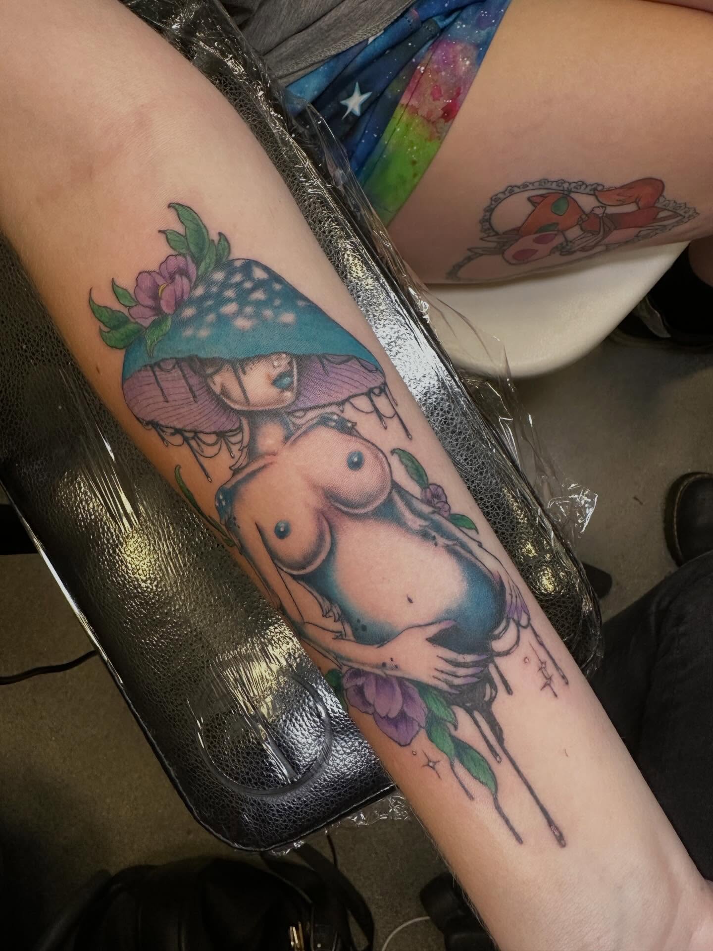 Nude woman with mushroom hat American traditional tattoo on the forearm by Michele Estes