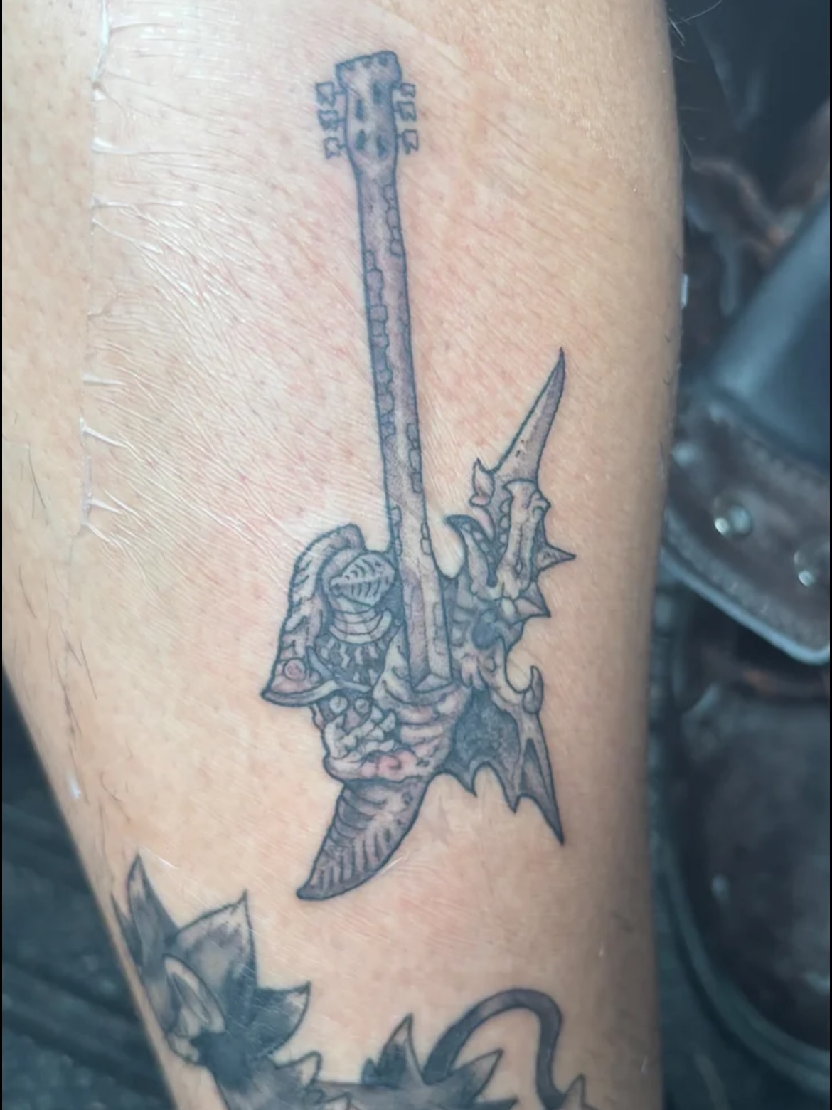 Guitar and knight black and grey tattoo on the forearm by Lauren