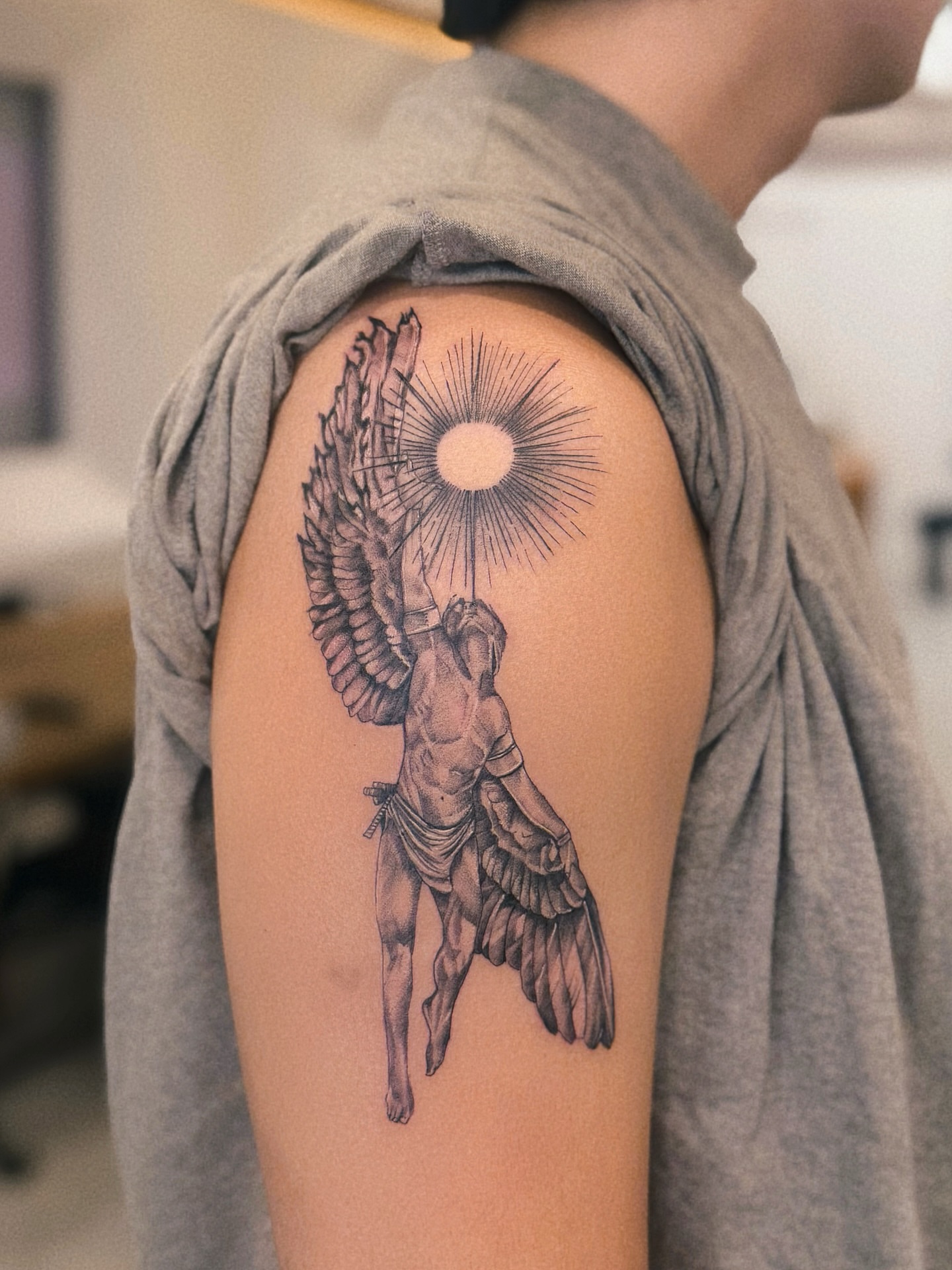 Angel with sun black and grey tattoo on the shoulder by MJ
