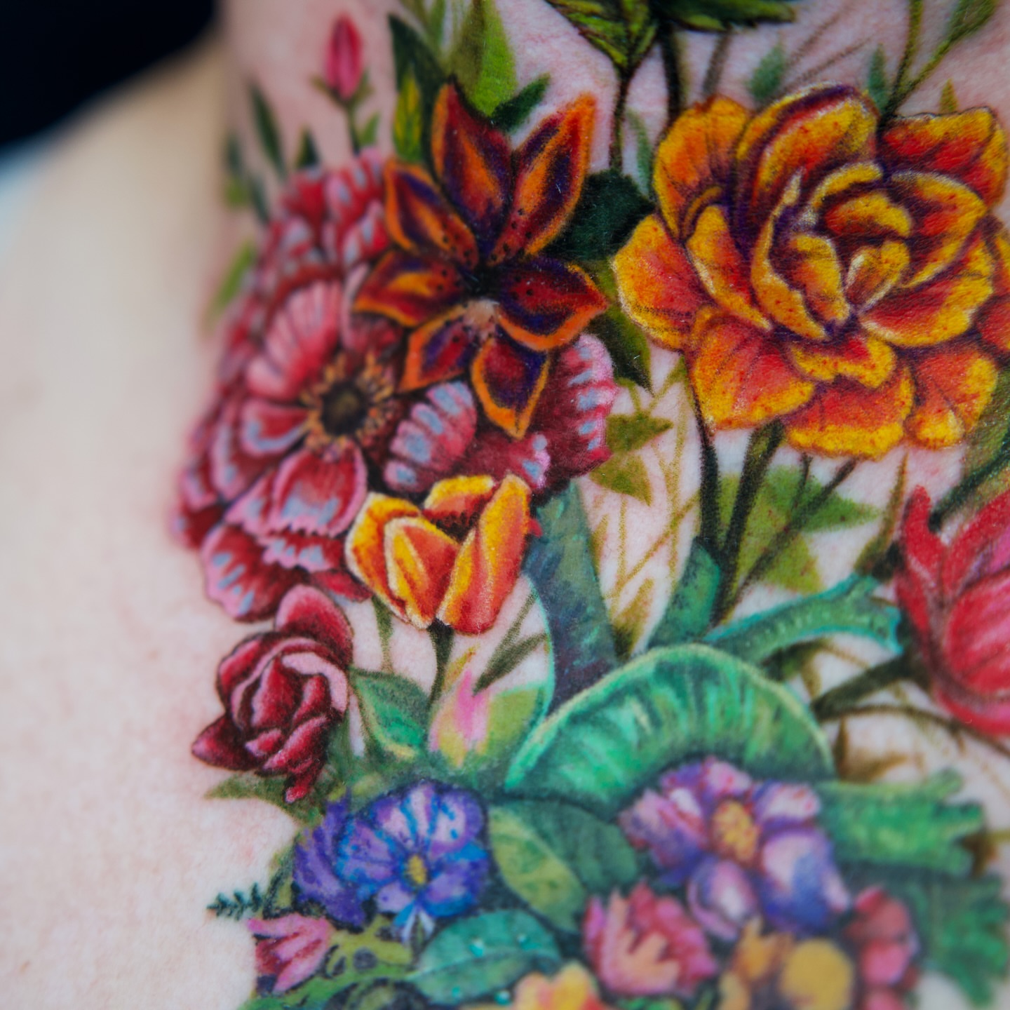 Floral bouquet realism tattoo on the chest by Raven Wood