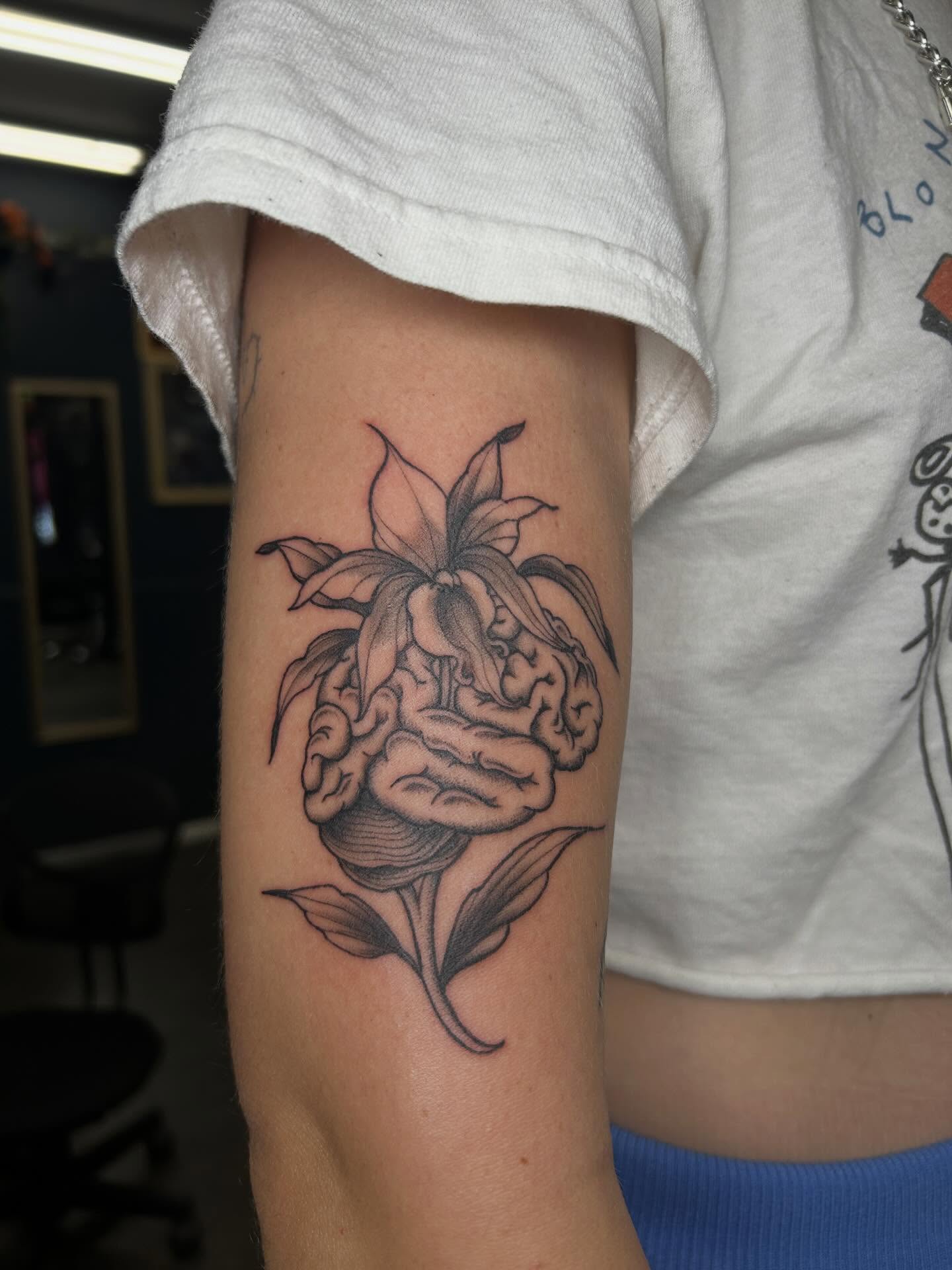 Brain and flower realism tattoo on the forearm by Janelle McCarthy