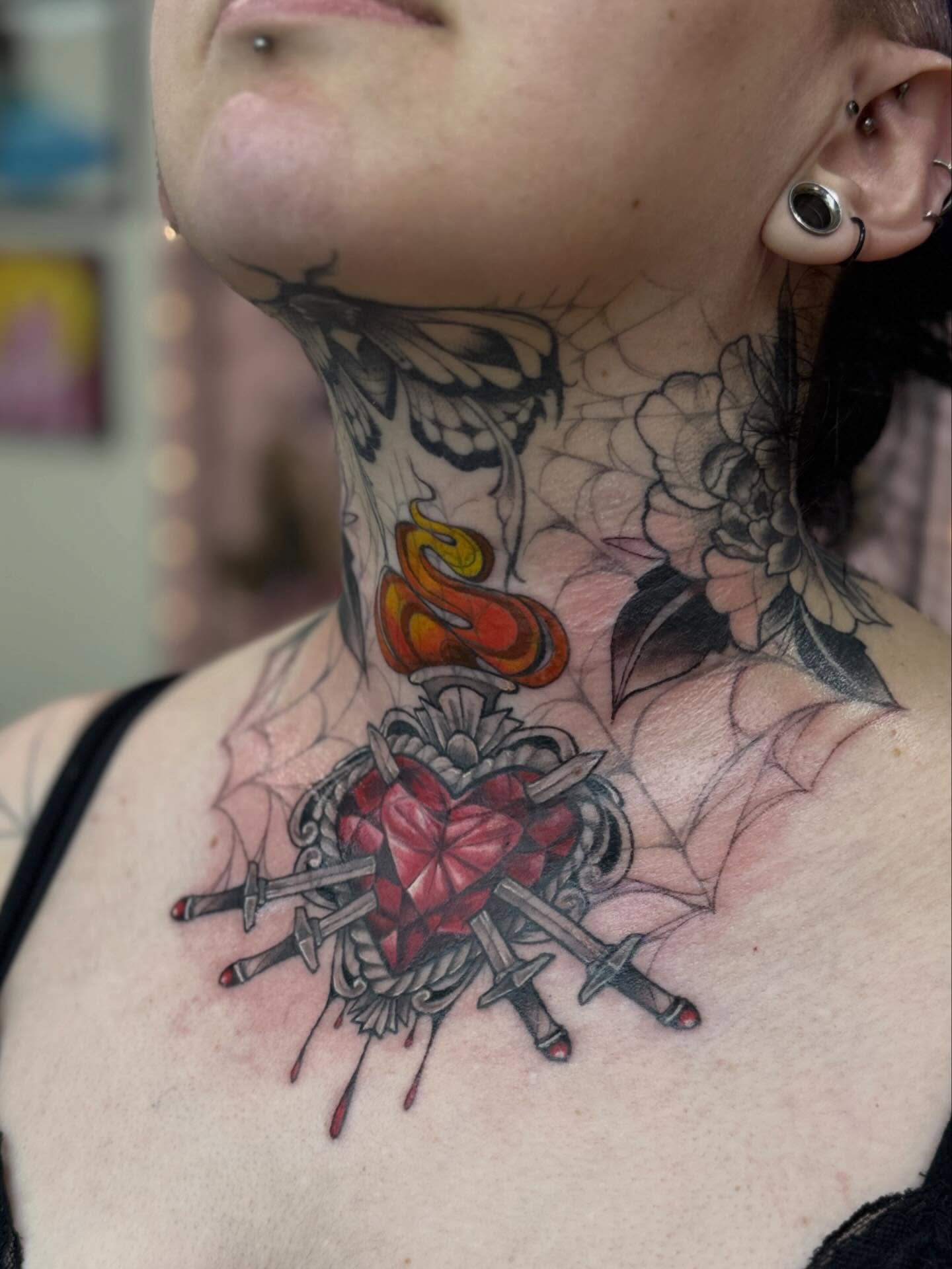 Heart with swords neo-traditional tattoo on the neck by Rebecca Rose