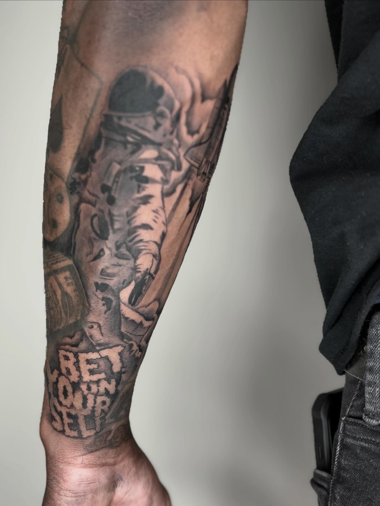 Astronaut black and grey tattoo on the forearm by Koolz