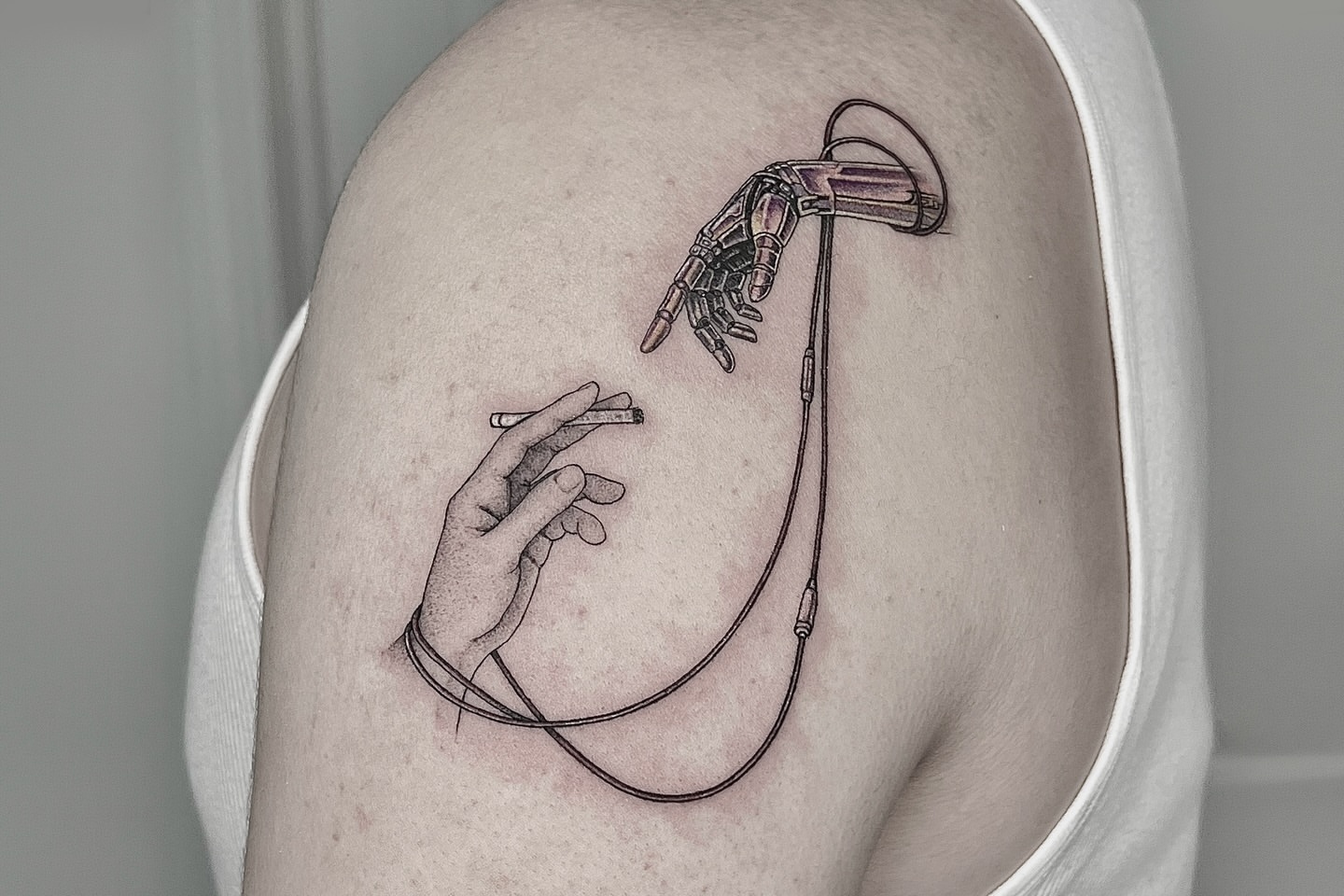 Robotic hand and human hand dotwork tattoo on the shoulder by X°