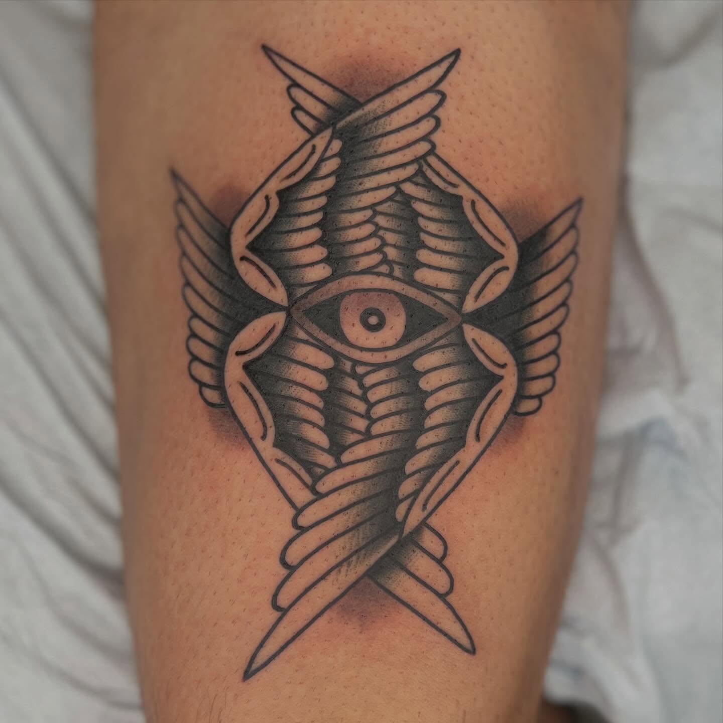 Eye with wings black and grey tattoo on the forearm by Mikey Montoya