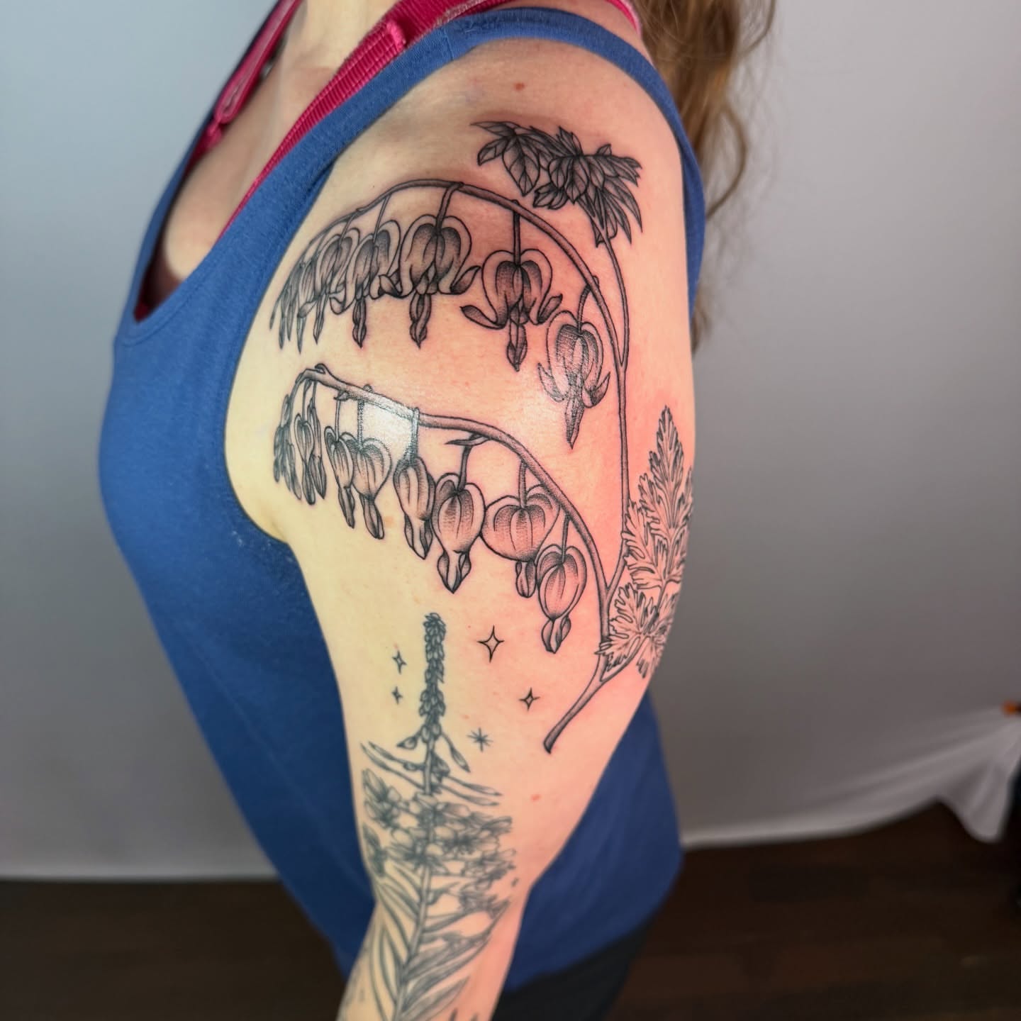 Heart-shaped flowers black and grey tattoo on the shoulder by Jenna Nicole