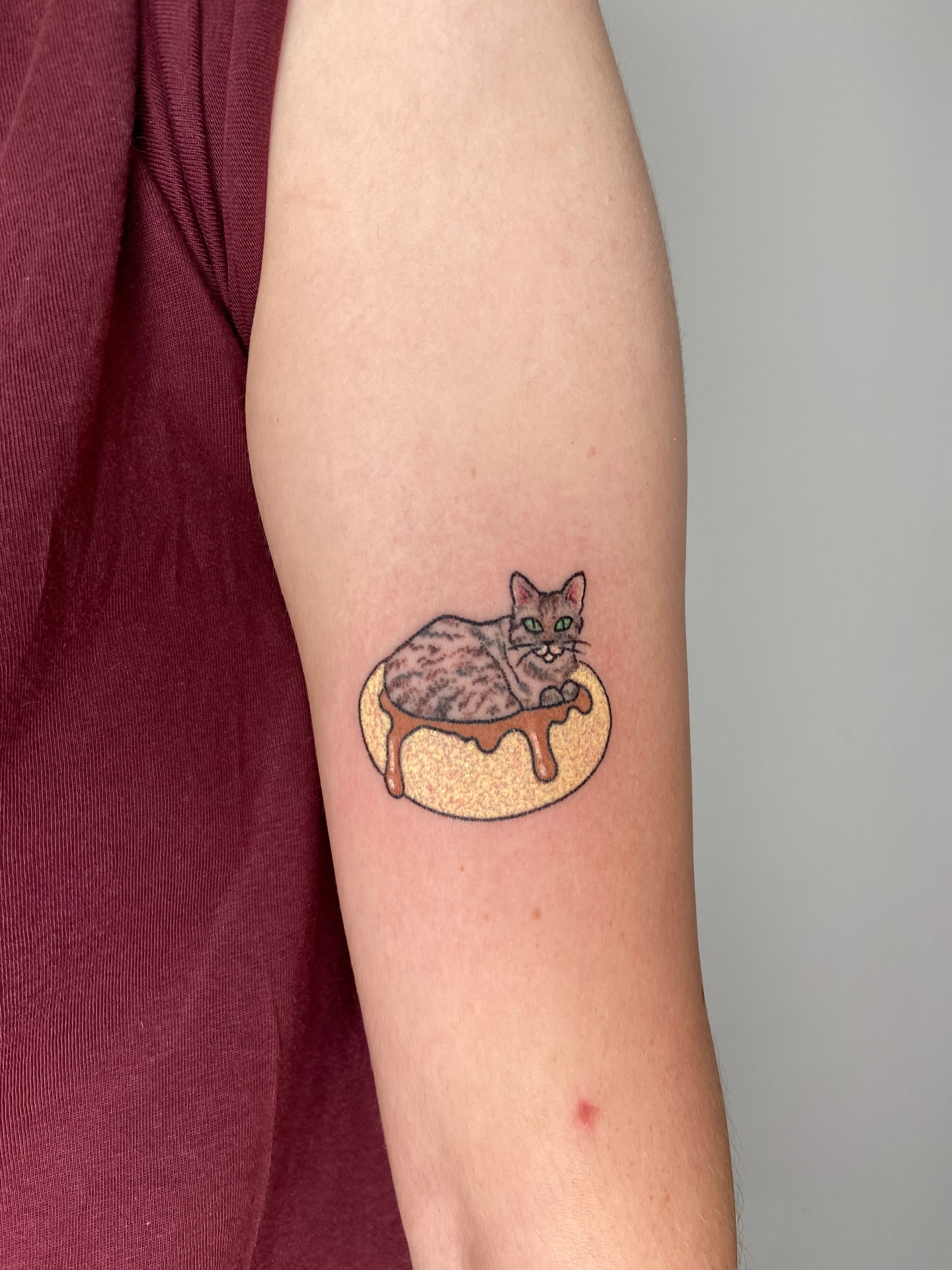 Cat in donut realism tattoo on the forearm by Kasia ✨jedyny taki handpoke w katowicach✨