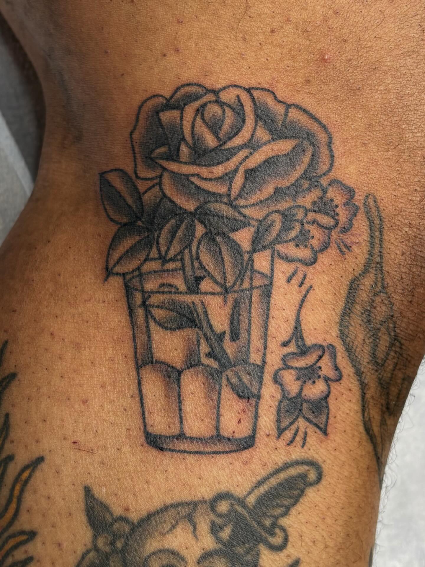Flower pot with rose black and grey tattoo on the thigh by Evan Bisso, Philadelphia, Pennsylvania