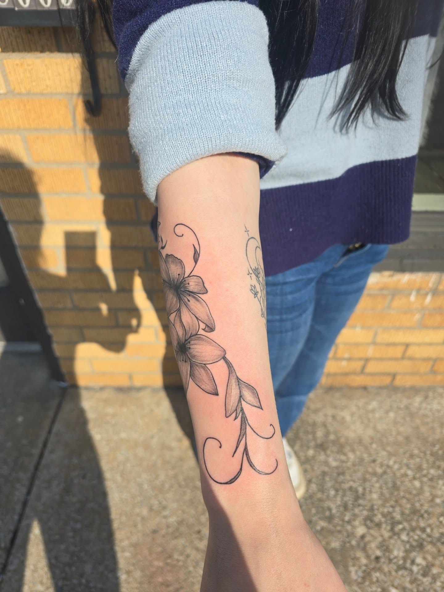 Lily black and grey tattoo on the forearm by Maddox Kitson🕷