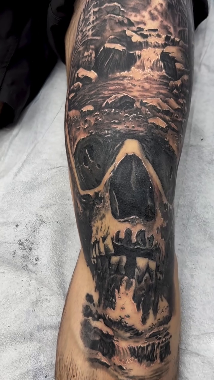 Skull with landscape dark realism tattoo by Steve Bishov