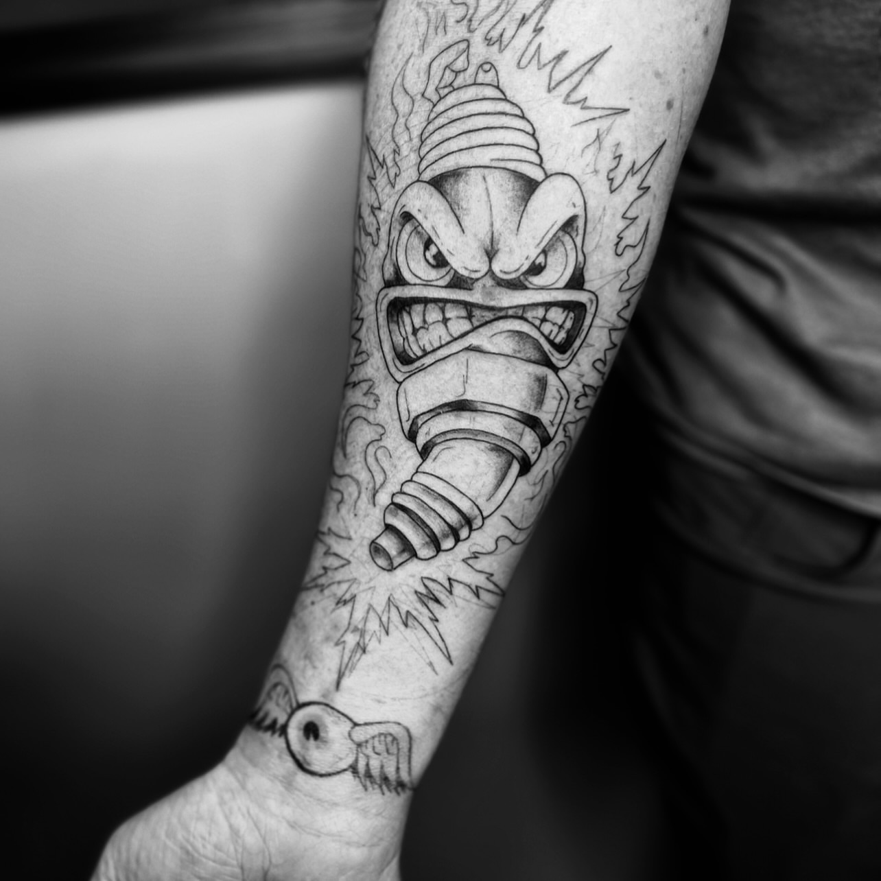 Bomb character black and grey tattoo on the forearm by Sydney Rose