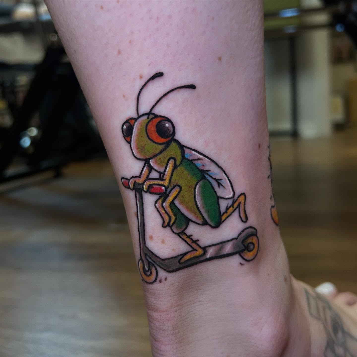 Insect riding scooter new school tattoo on the forearm by Sarah π€π»