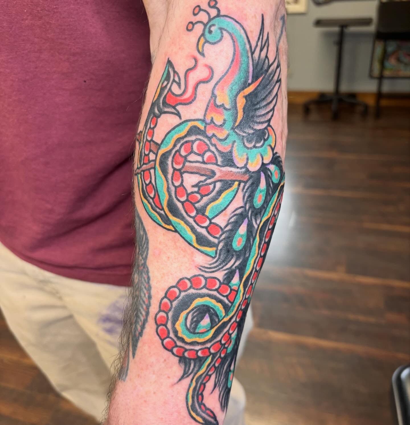 Peacock and snake American traditional tattoo on the forearm by Steve Reid