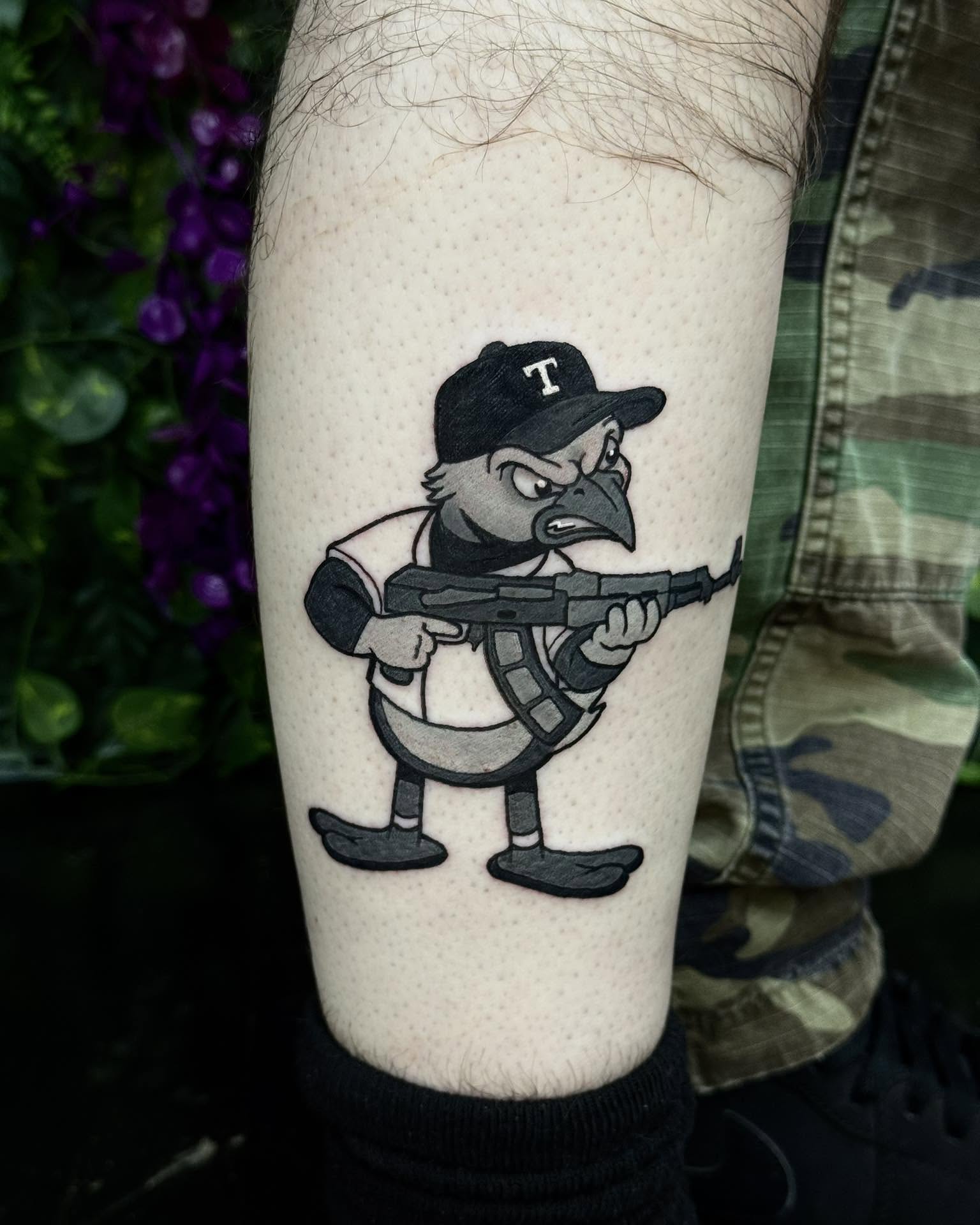 Raven with gun black and grey tattoo on the forearm by Sabrina