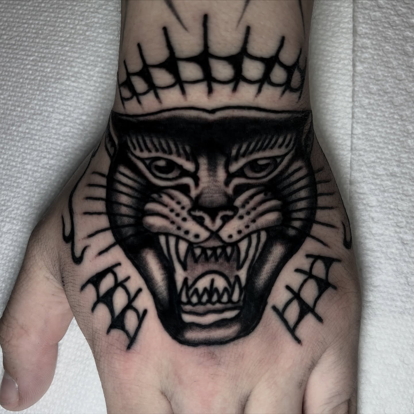 Panther black and grey tattoo on the hand by π³πππ πΆπππππ