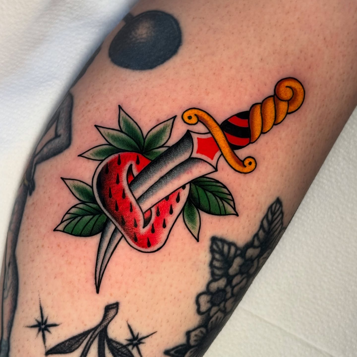 Strawberry and dagger American traditional tattoo on the forearm by Chelstine, Encinitas, California