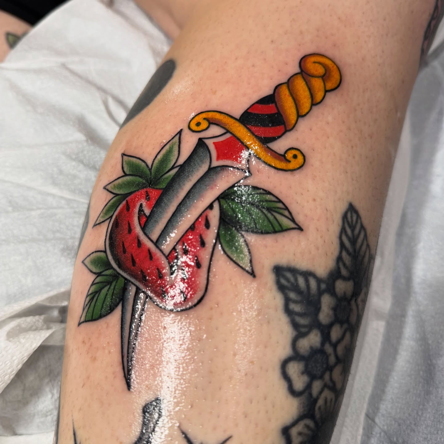 Strawberry and knife American traditional tattoo on the forearm by Chelstine, Encinitas, California