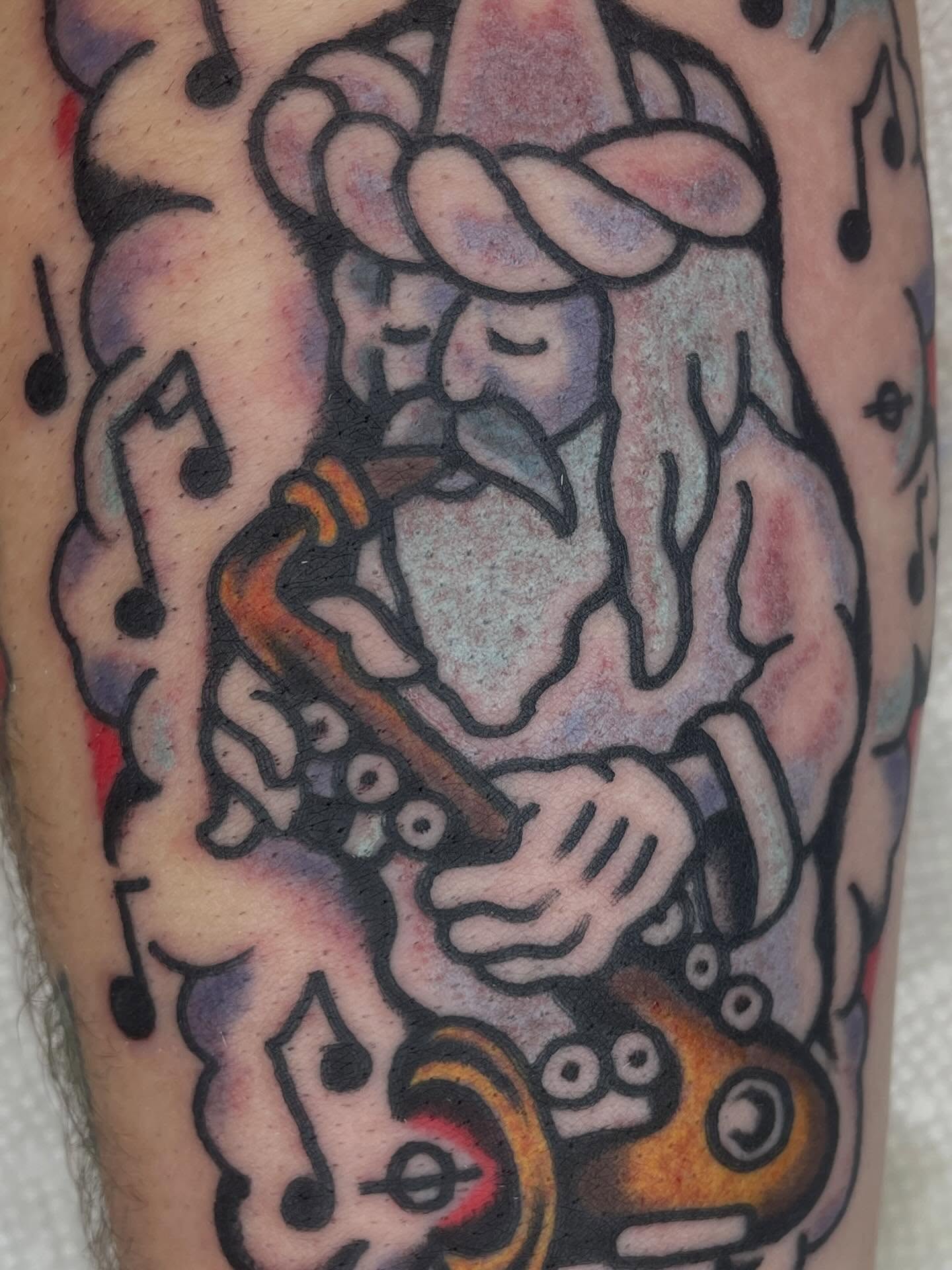 Jester playing a trumpet American traditional tattoo on the forearm by Nicholas M. Passeri