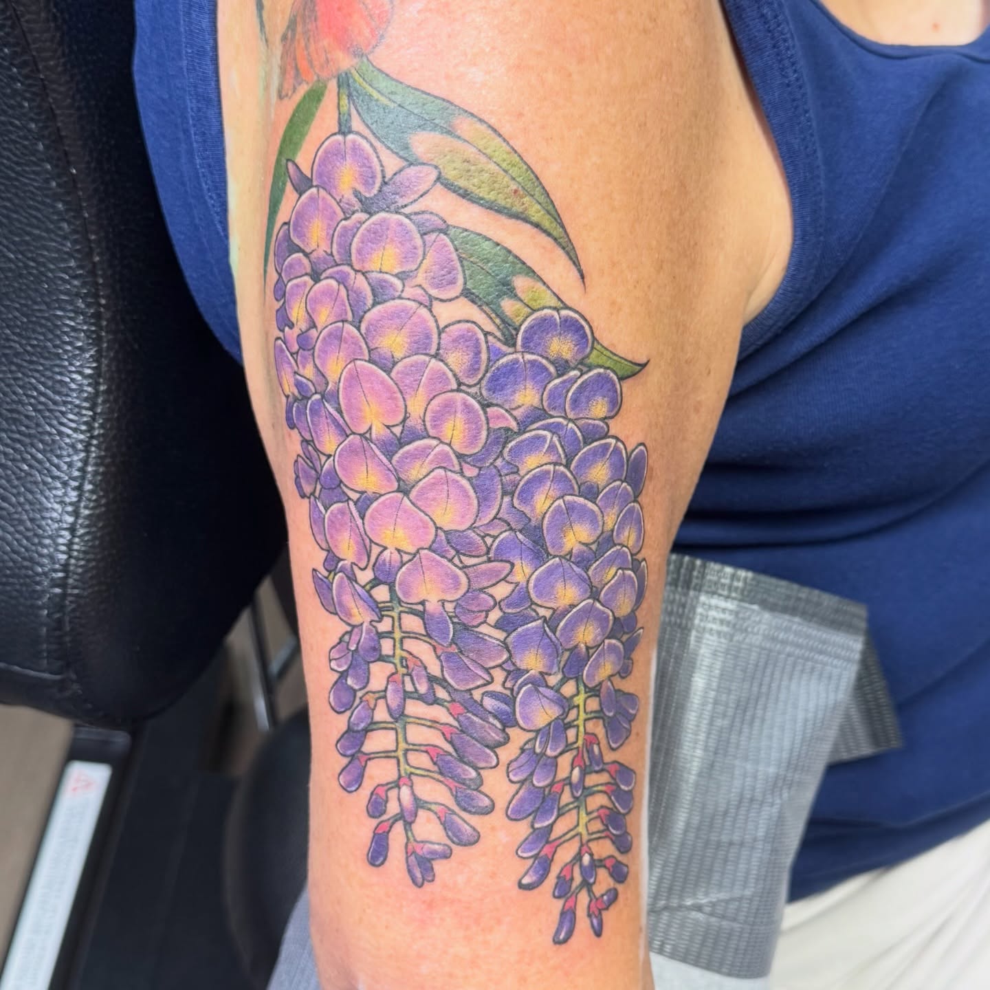 Wisteria flowers realism tattoo on the forearm by Bri
