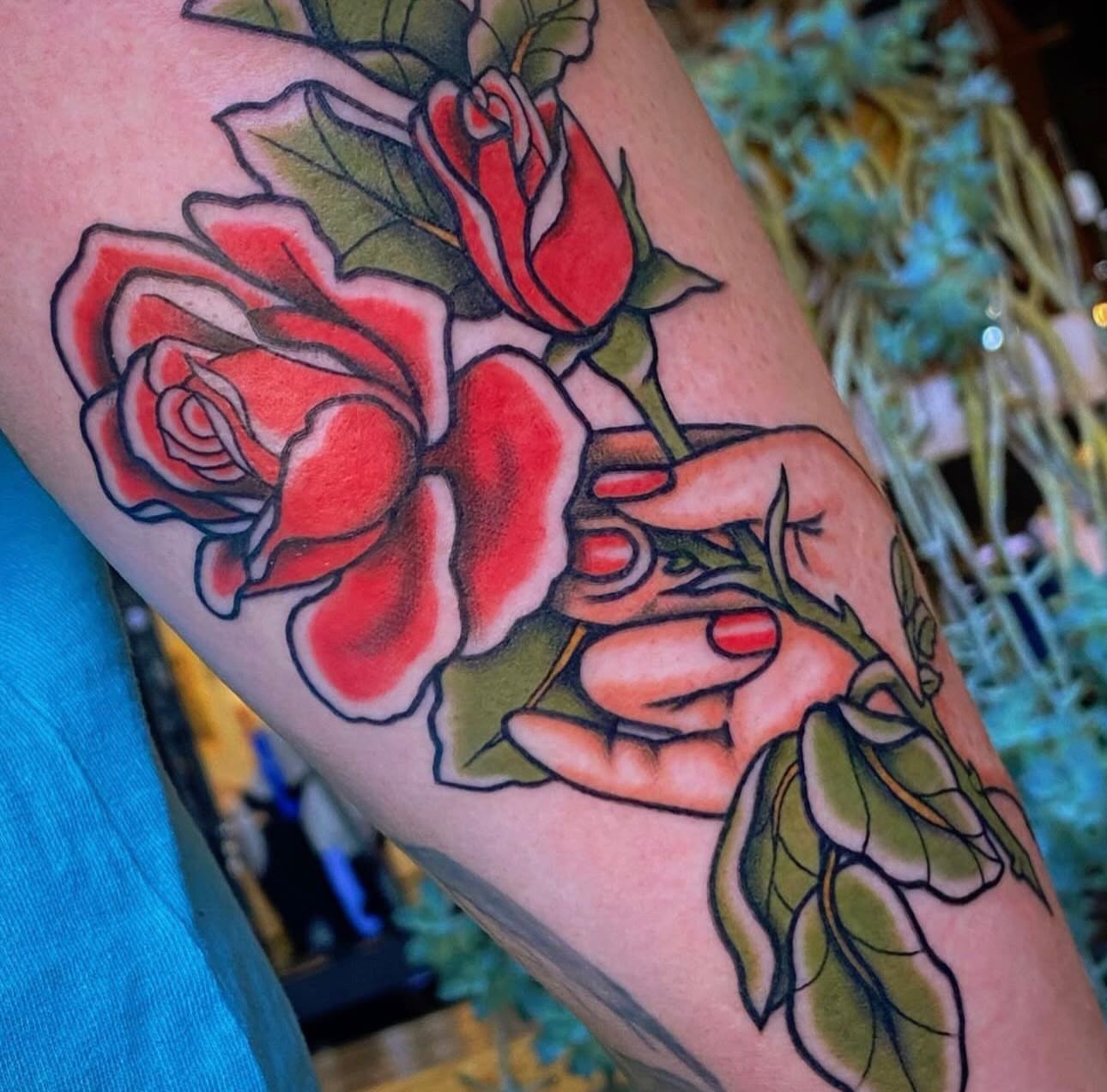Red roses American traditional tattoo on the forearm by Nikki Bee