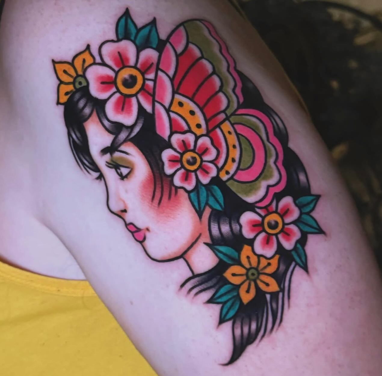 Floral headdress American traditional tattoo on the shoulder by Nikki Bee