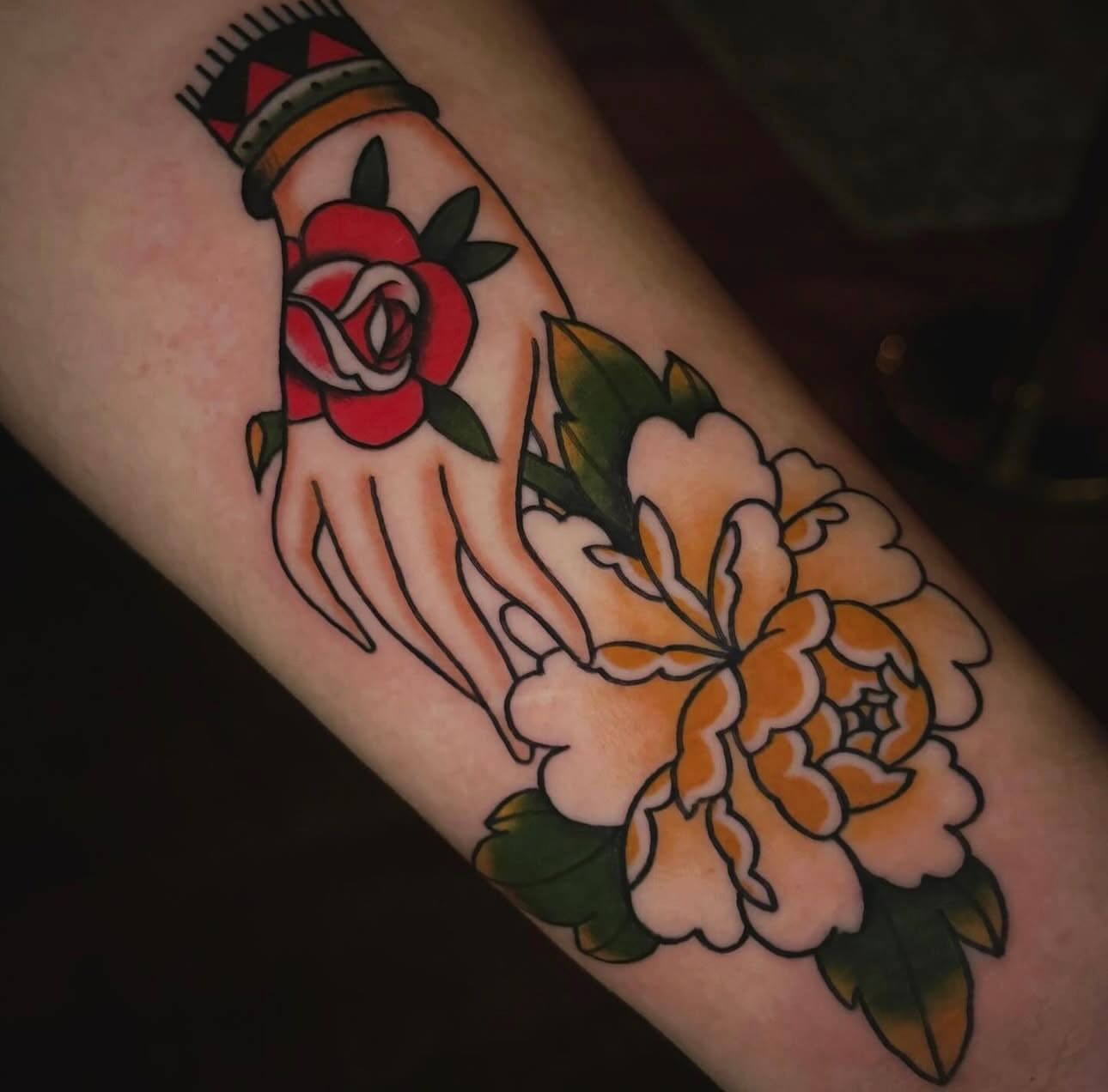 Hand with flowers American traditional tattoo on the forearm by Nikki Bee