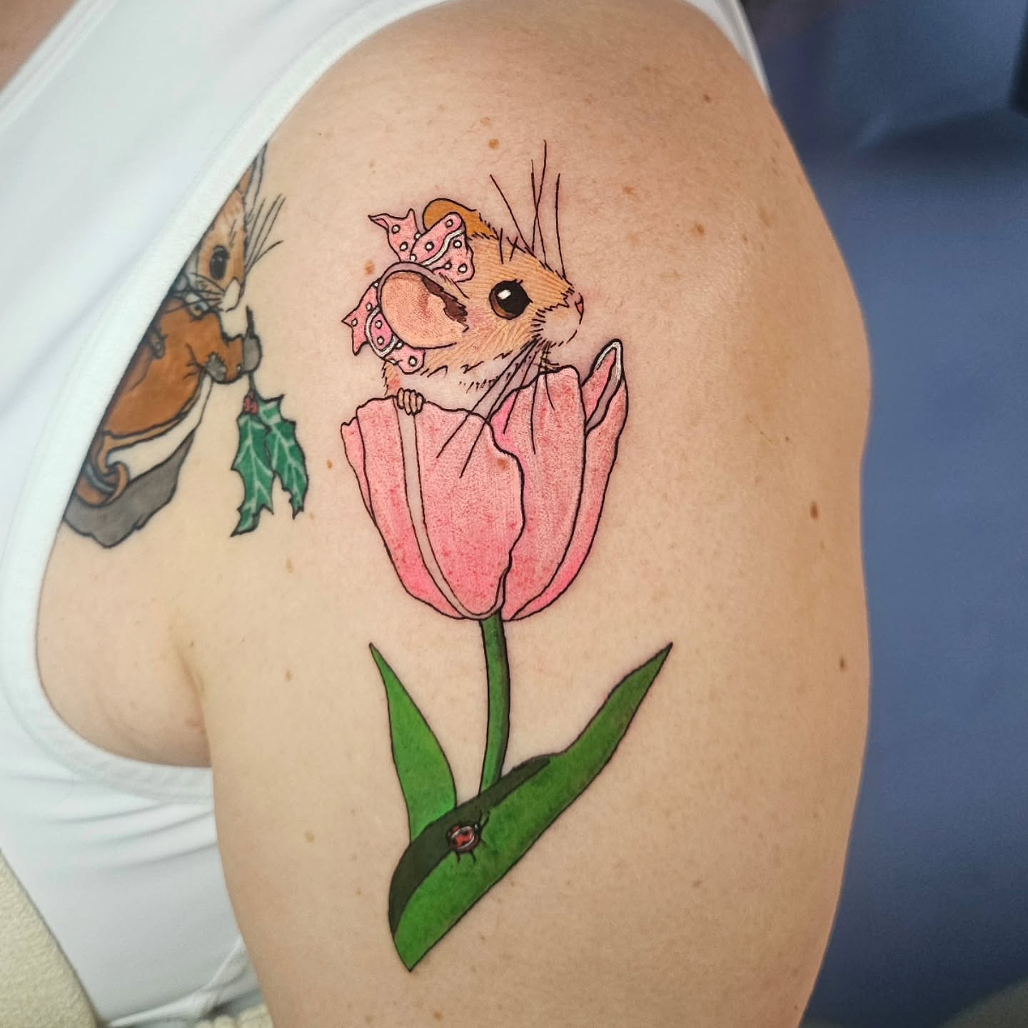 Hamster in tulip illustrative tattoo on the shoulder by Gray